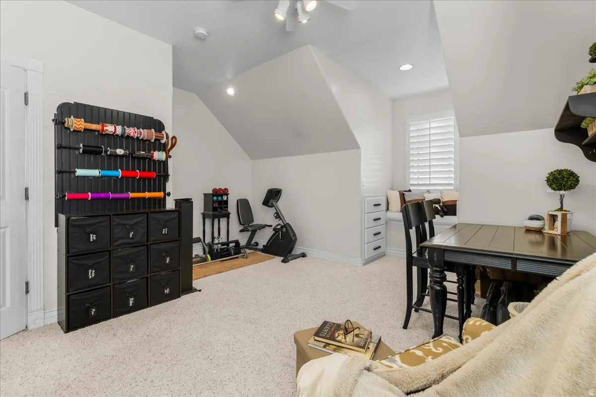 Interior space with light carpet, vaulted ceiling, recessed lighting, and ceiling fan