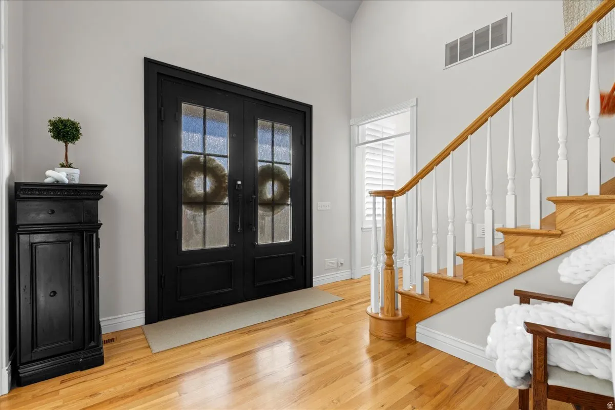 Foyer with stairs, plenty of natural light, and light wood-style floors
