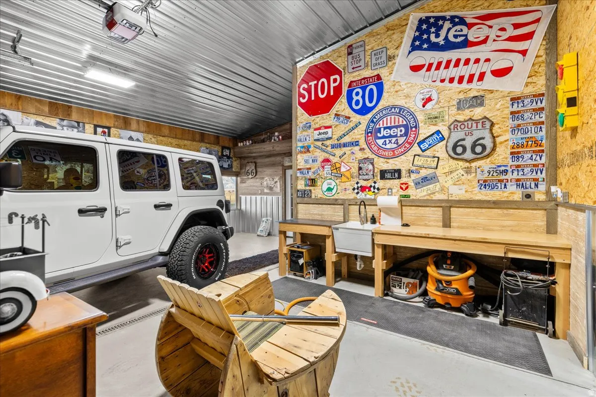 Garage featuring wooden walls, a garage door opener, and a workshop area