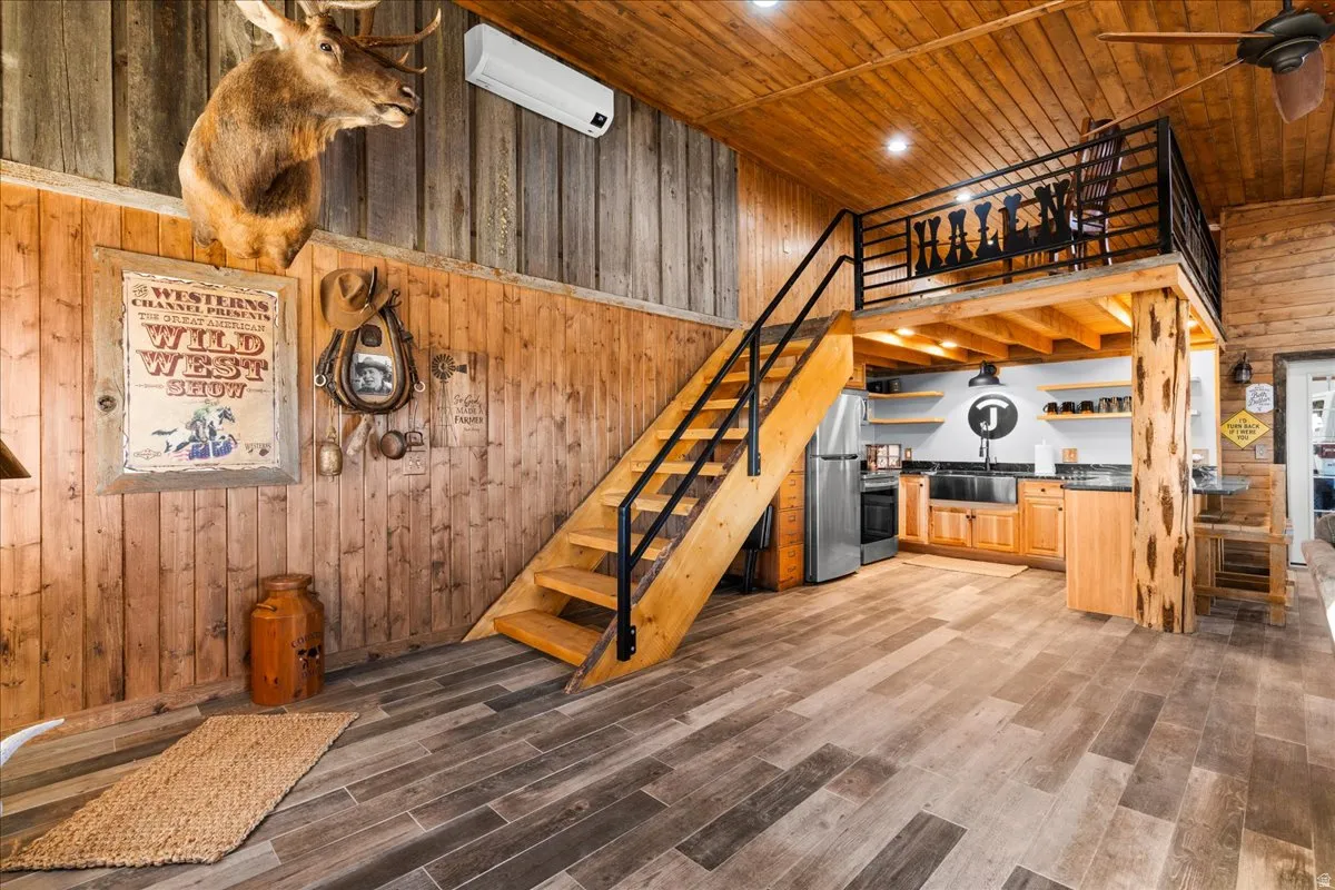 Stairway featuring wood walls, wood ceiling, wood finished floors, an AC wall unit, and recessed lighting