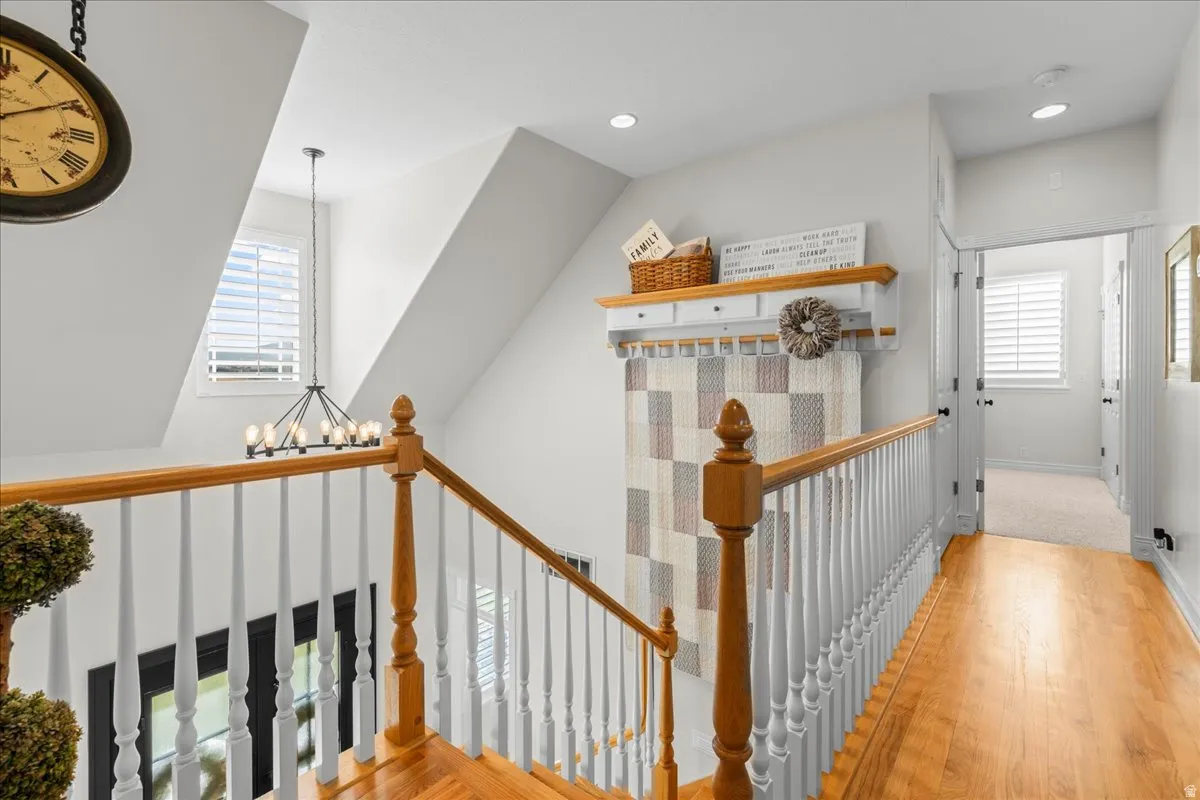 Corridor featuring healthy amount of natural light, an upstairs landing, light wood-type flooring, and recessed lighting