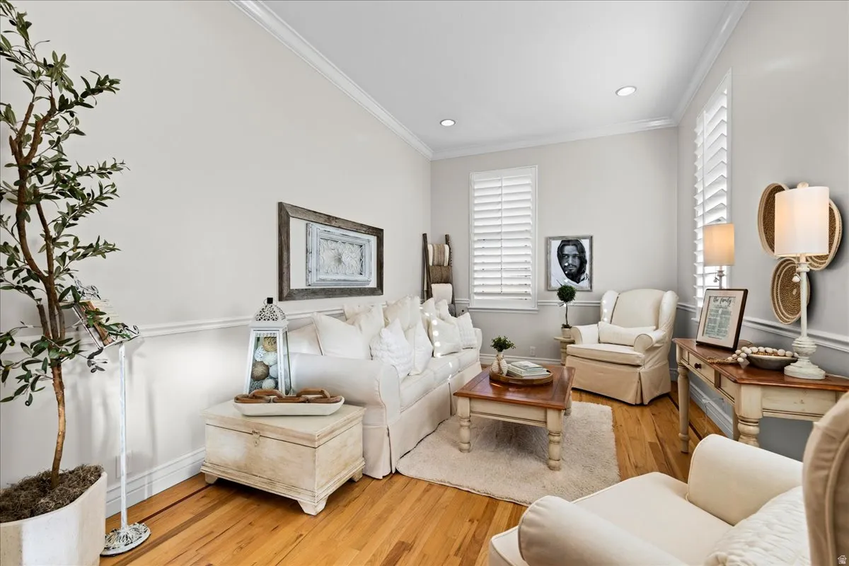 Living area featuring light wood-style flooring, ornamental molding, healthy amount of natural light, and recessed lighting