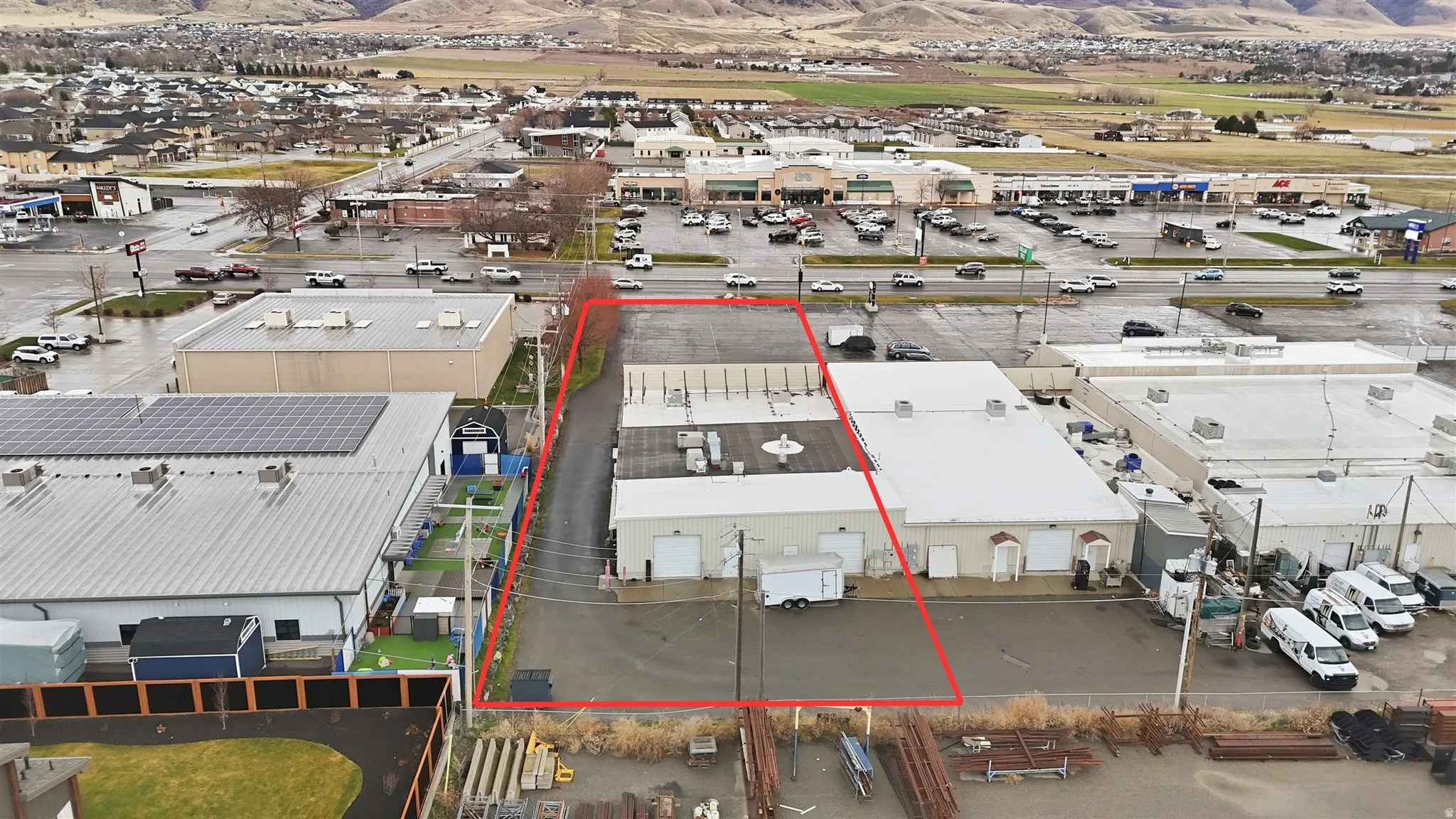 Aerial view of property and surrounding area featuring industrial structures and property boundaries highlighted