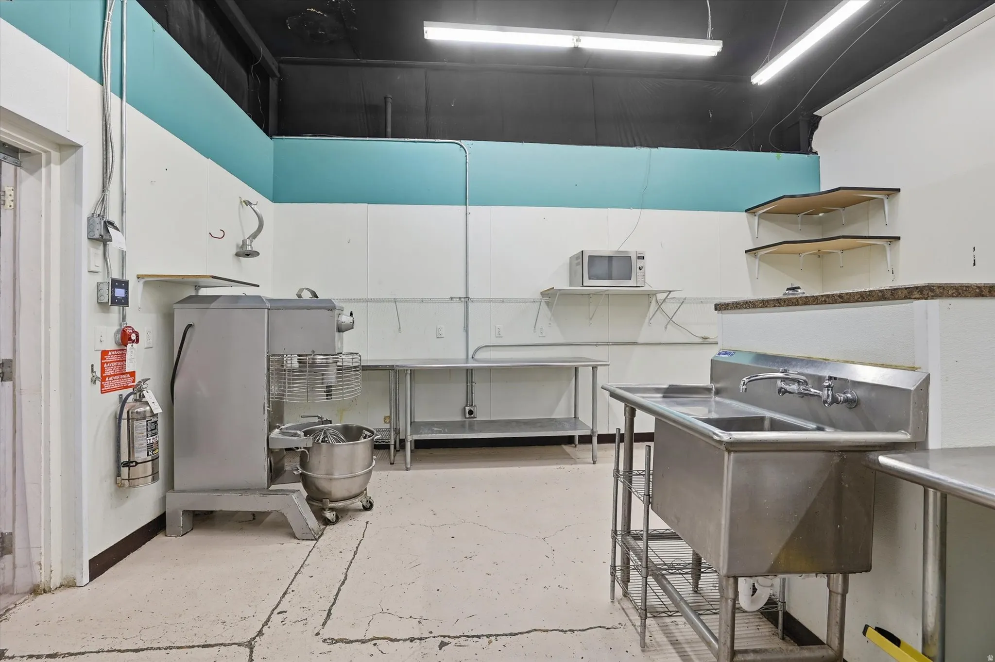 Kitchen featuring white cabinets and stainless steel microwave