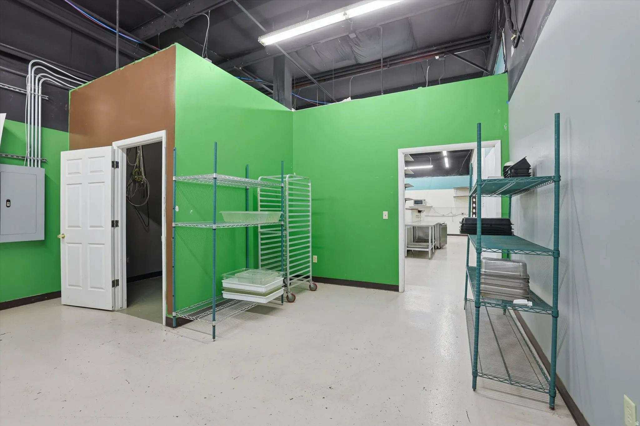 Miscellaneous room with finished concrete floors and a high ceiling