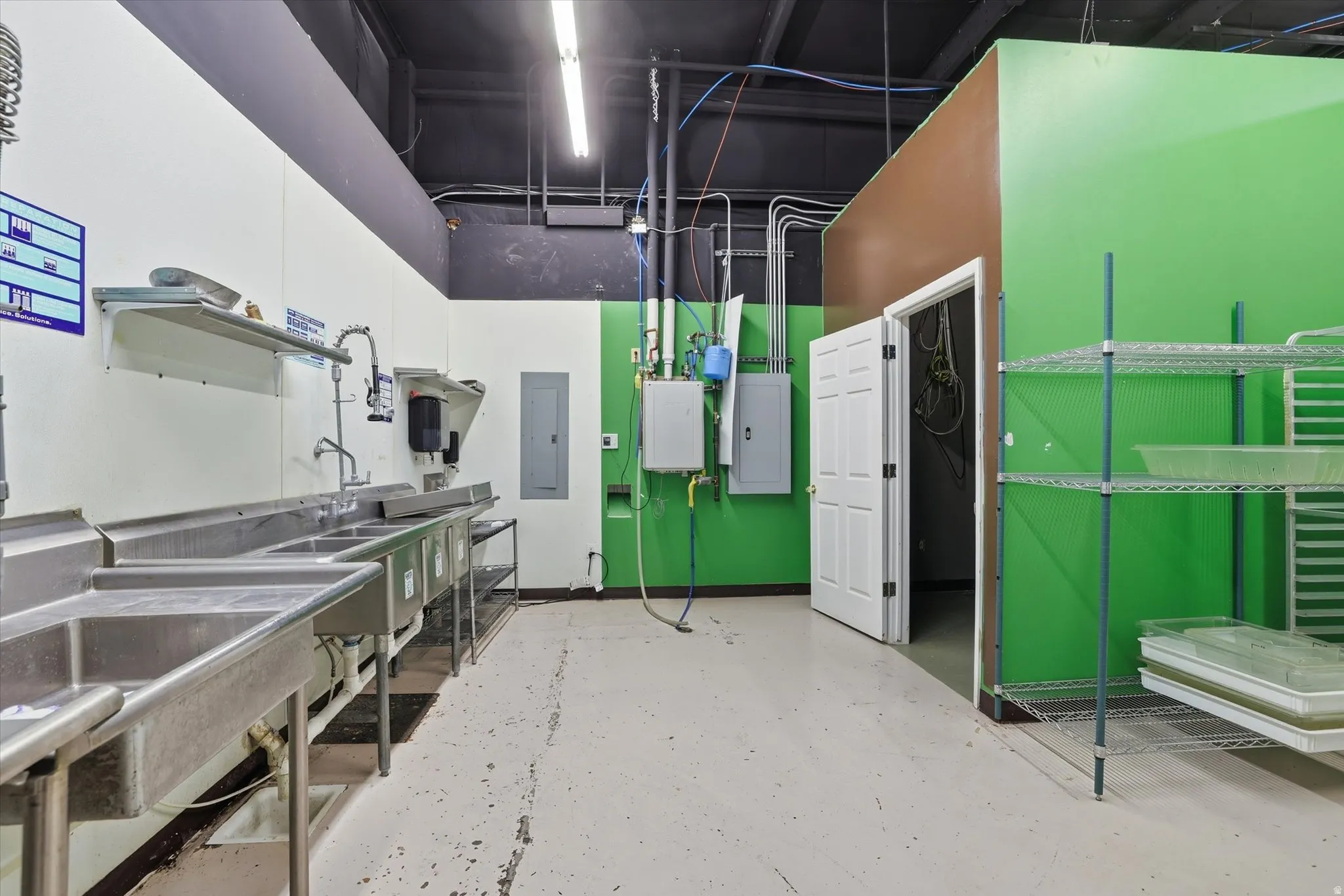 Kitchen featuring electric panel and white cabinetry