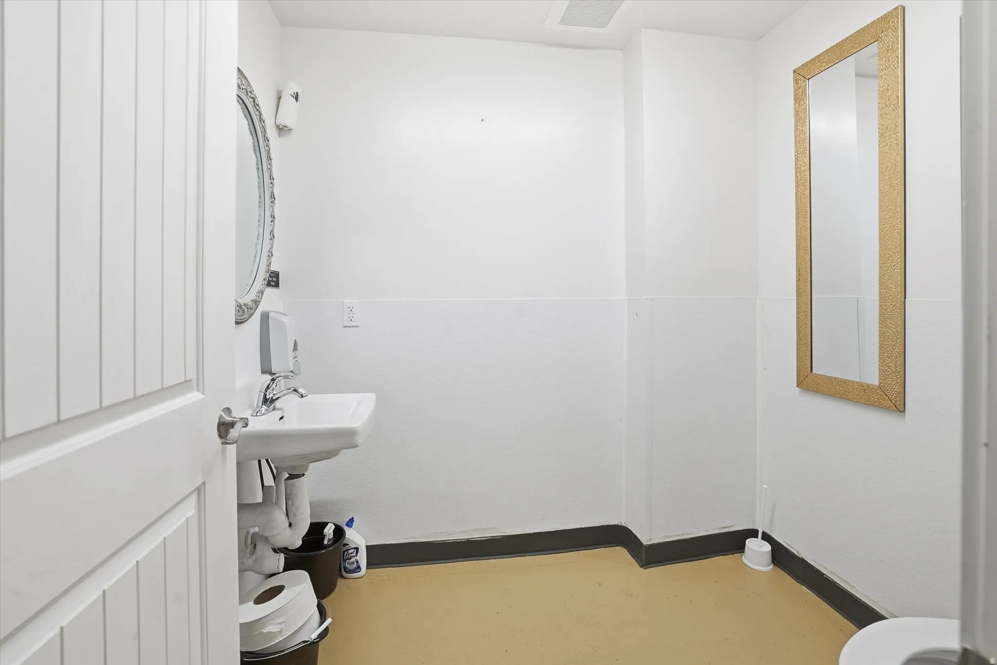 Half bath featuring baseboards and concrete flooring