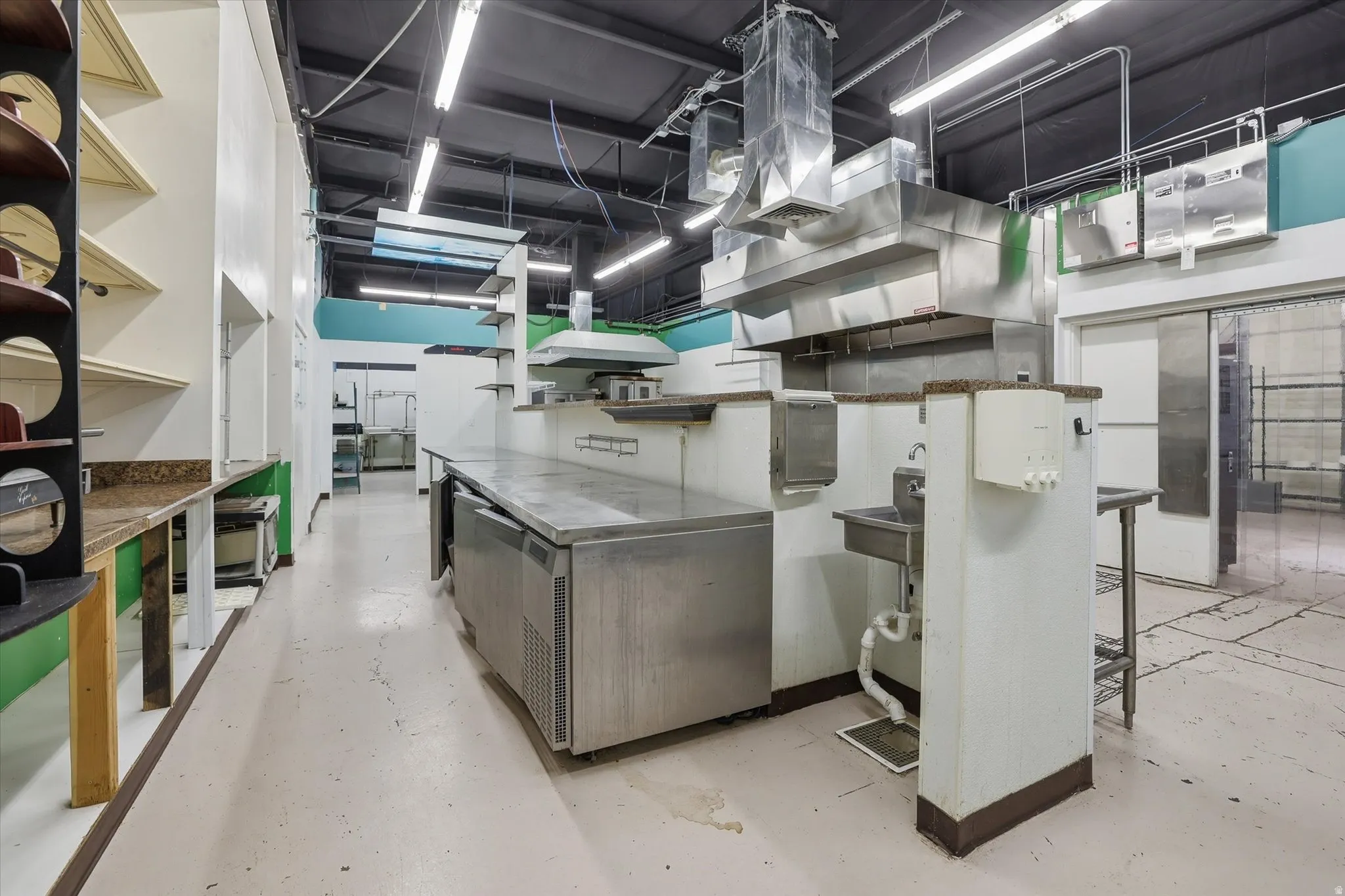 Kitchen with stainless steel countertops, modern cabinets, a breakfast bar area, and open shelves