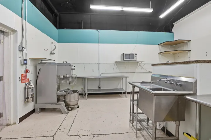 Kitchen featuring white cabinets and stainless steel microwave