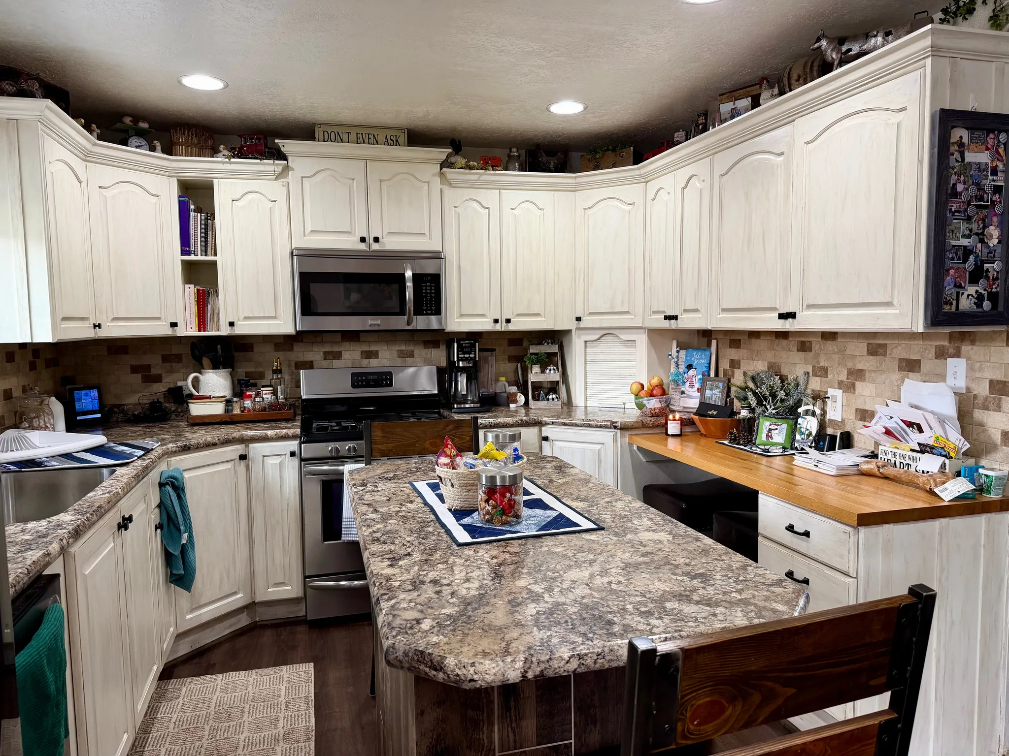 Kitchen featuring appliances with stainless steel finishes, open shelves, a center island, recessed lighting, and Luxury vinyl flooring