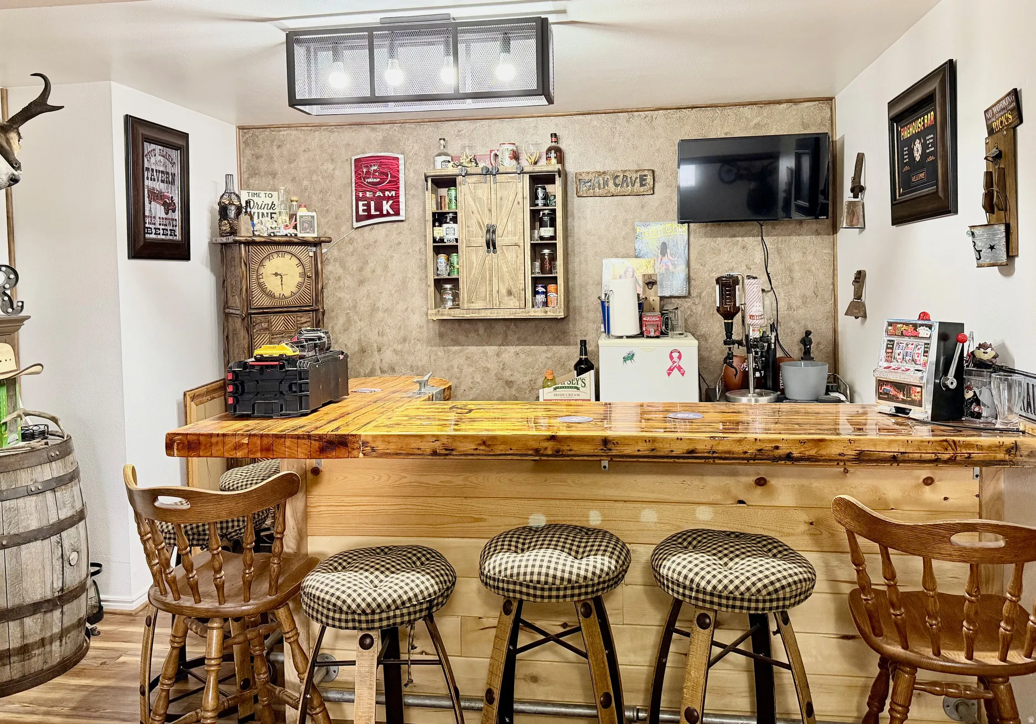 Indoor dry bar featuring butcher block countertops and wood finished floors