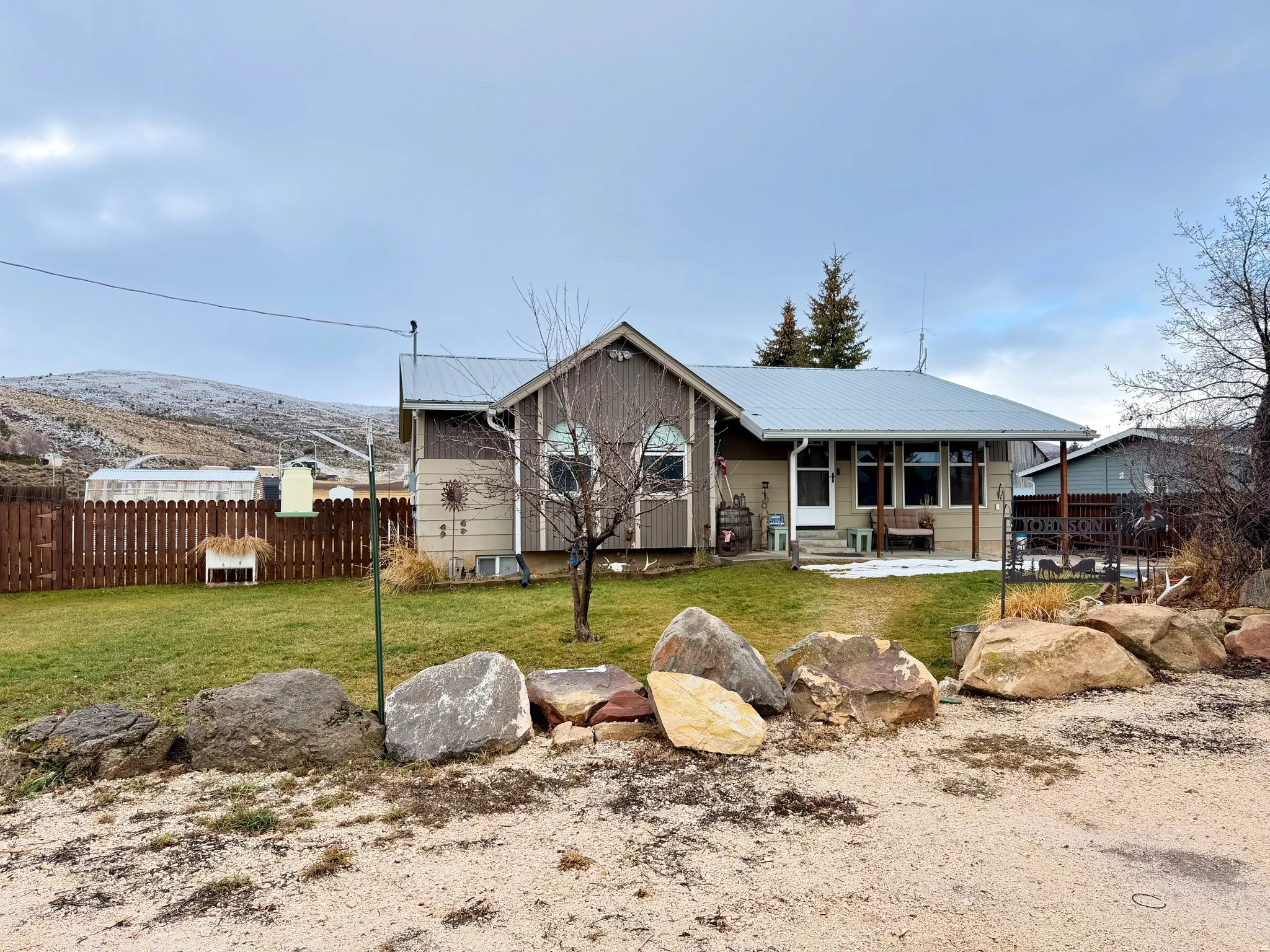 View of front of property with a covered porch and a metal roof.