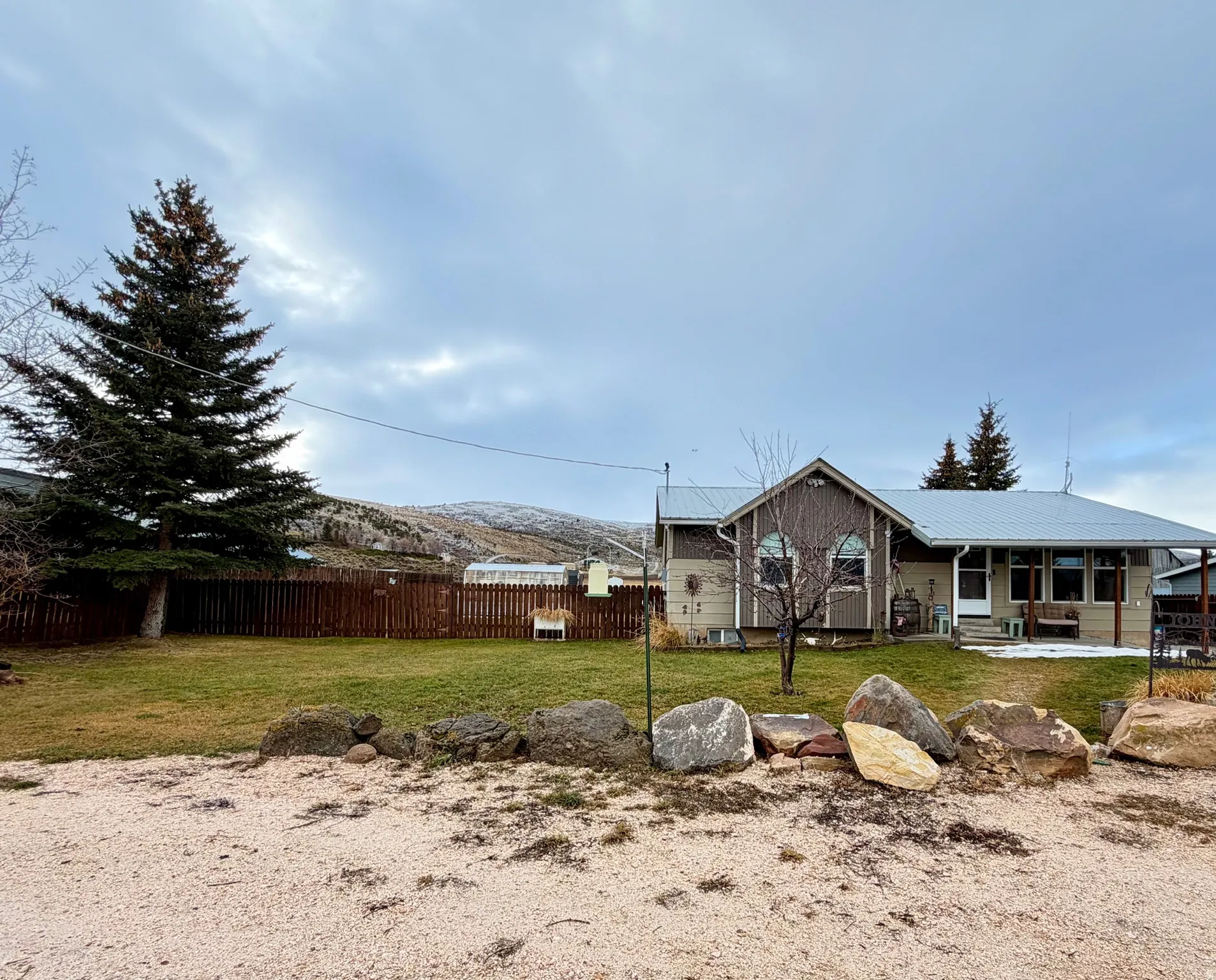 View of front of property with a metal roof and fenced yard.