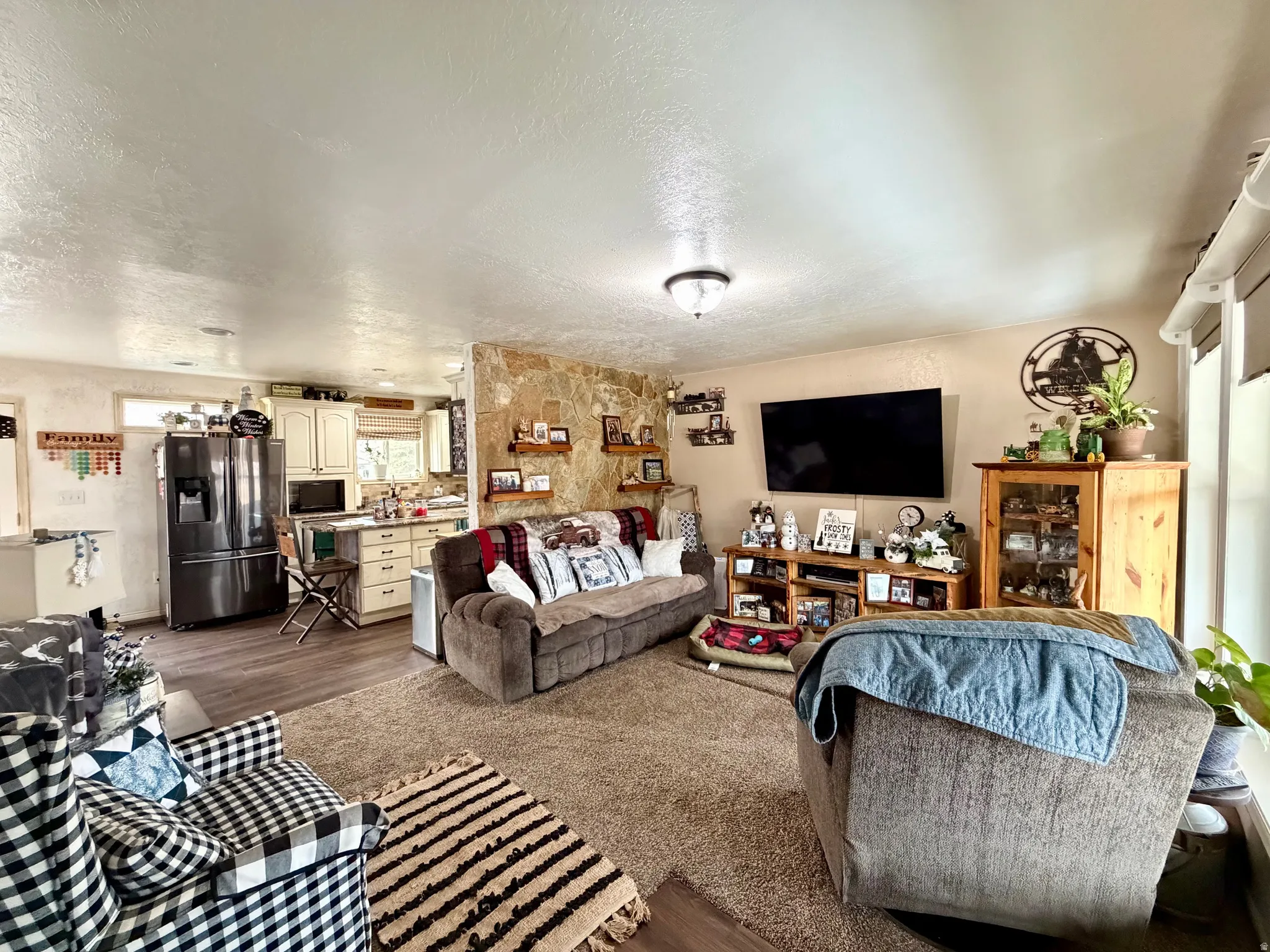 Living area featuring a textured ceiling carpet and Luxury vinyl floors