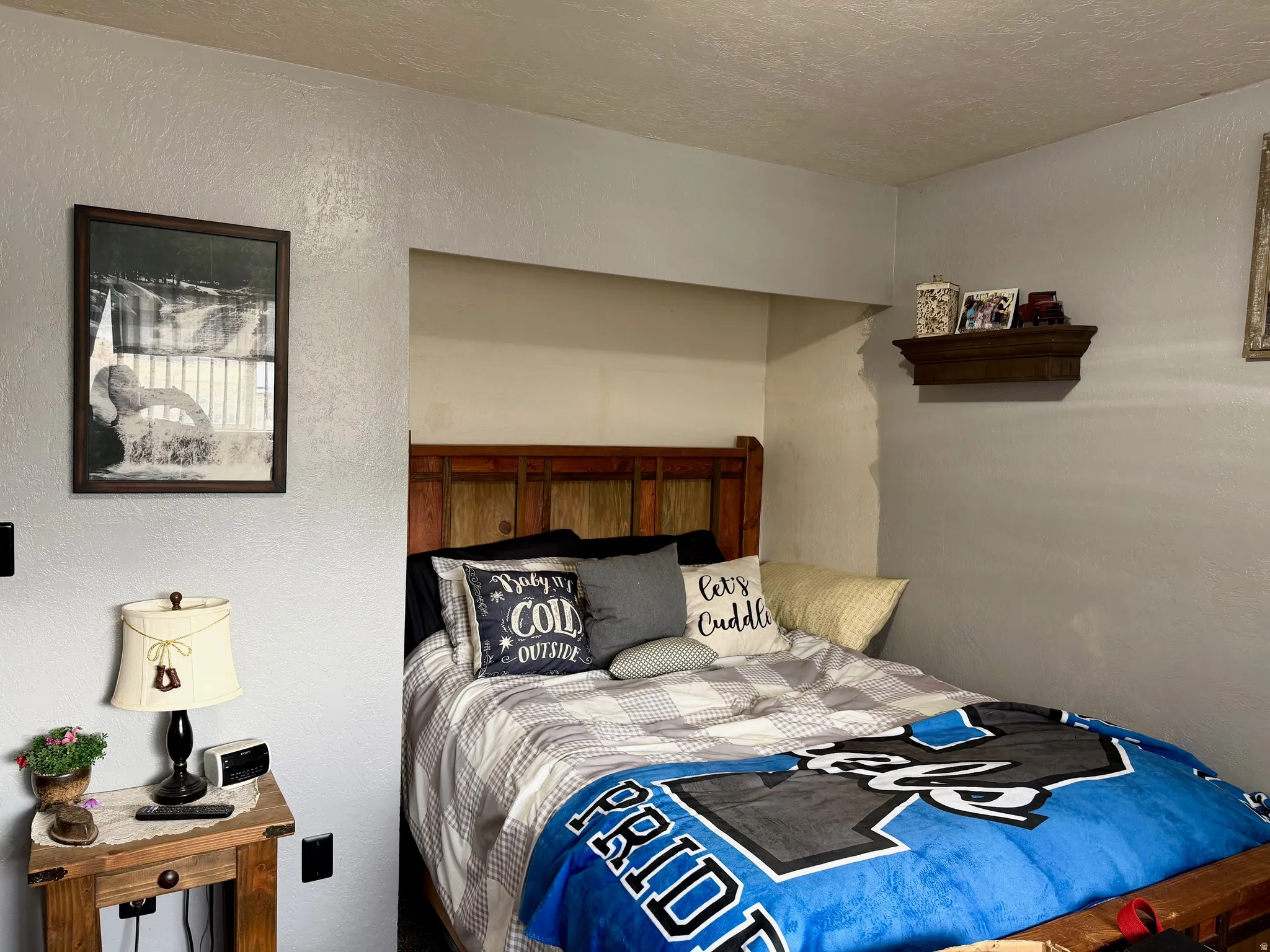 Bedroom with a textured wall and a textured ceiling