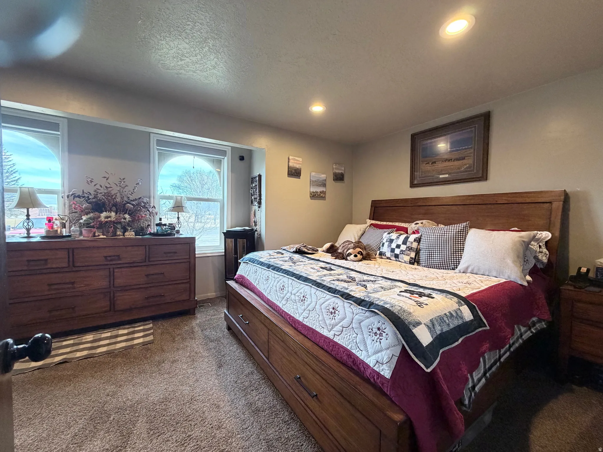Bedroom with dark colored carpet, a textured ceiling, and recessed lighting