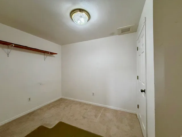 Spare room with light colored carpet and baseboards