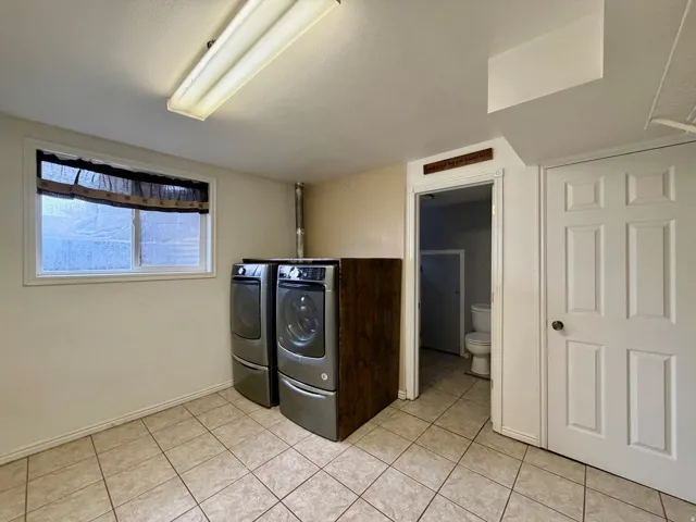Laundry area featuring washer and dryer and light tile patterned flooring