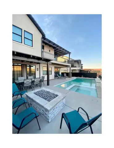 Outdoor pool with a fire pit, a balcony, and a patio