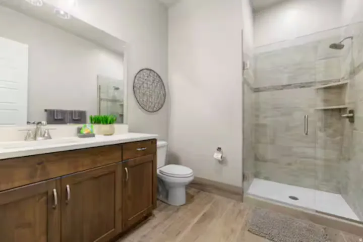 Full bath featuring vanity, a shower stall, and light wood-style flooring