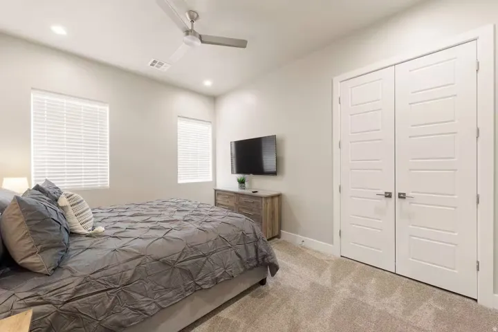 Bedroom featuring light colored carpet, a closet, ceiling fan, and recessed lighting