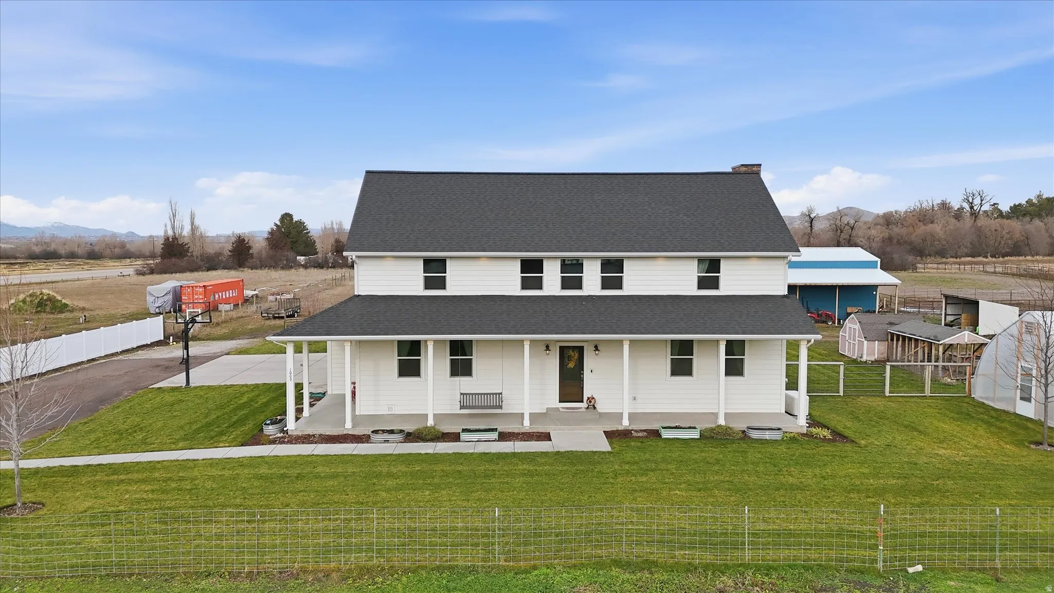 View of front facade with covered porch and a shingled roof