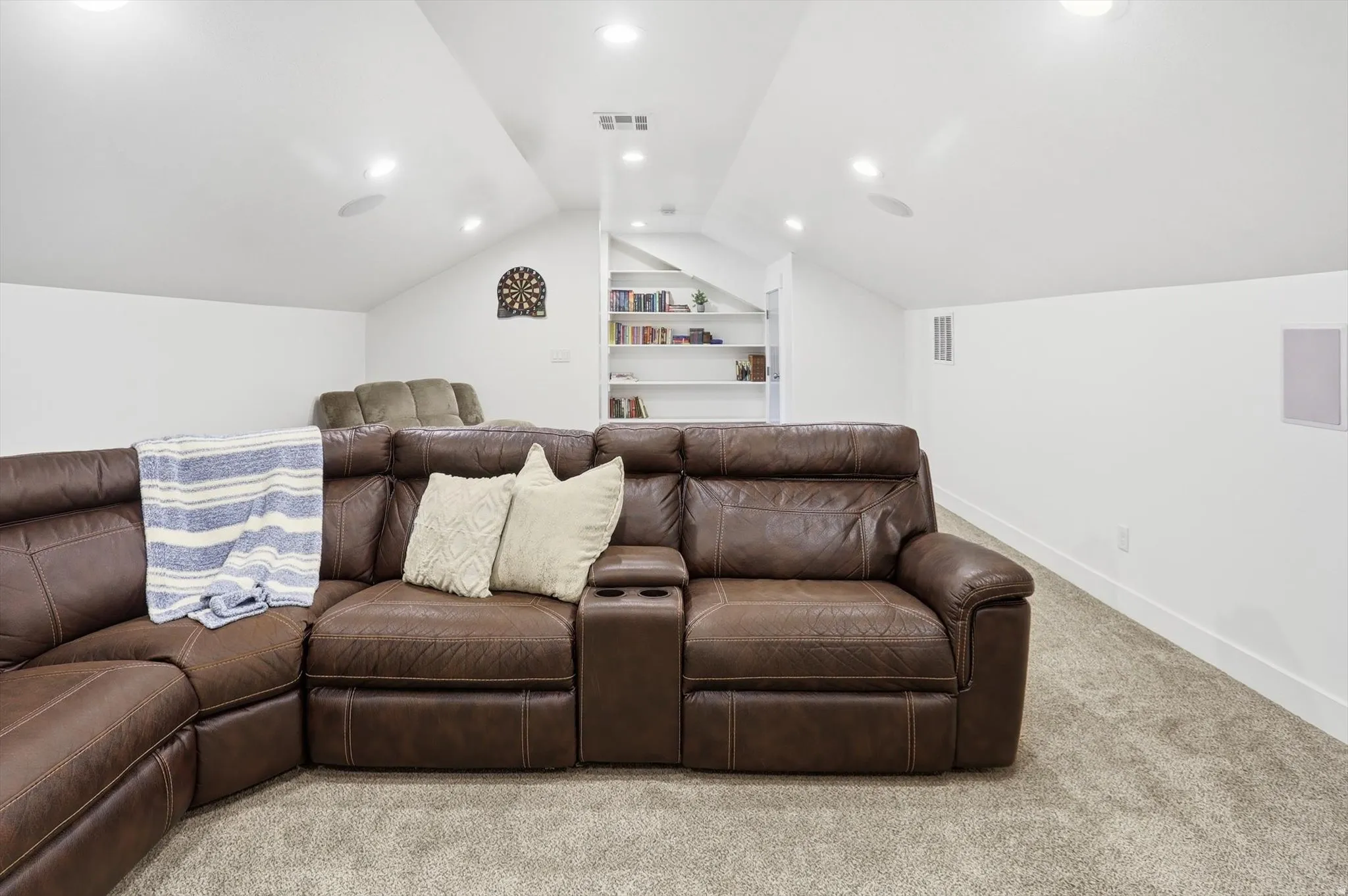 Home theater room featuring carpet, built in shelves, vaulted ceiling, and recessed lighting