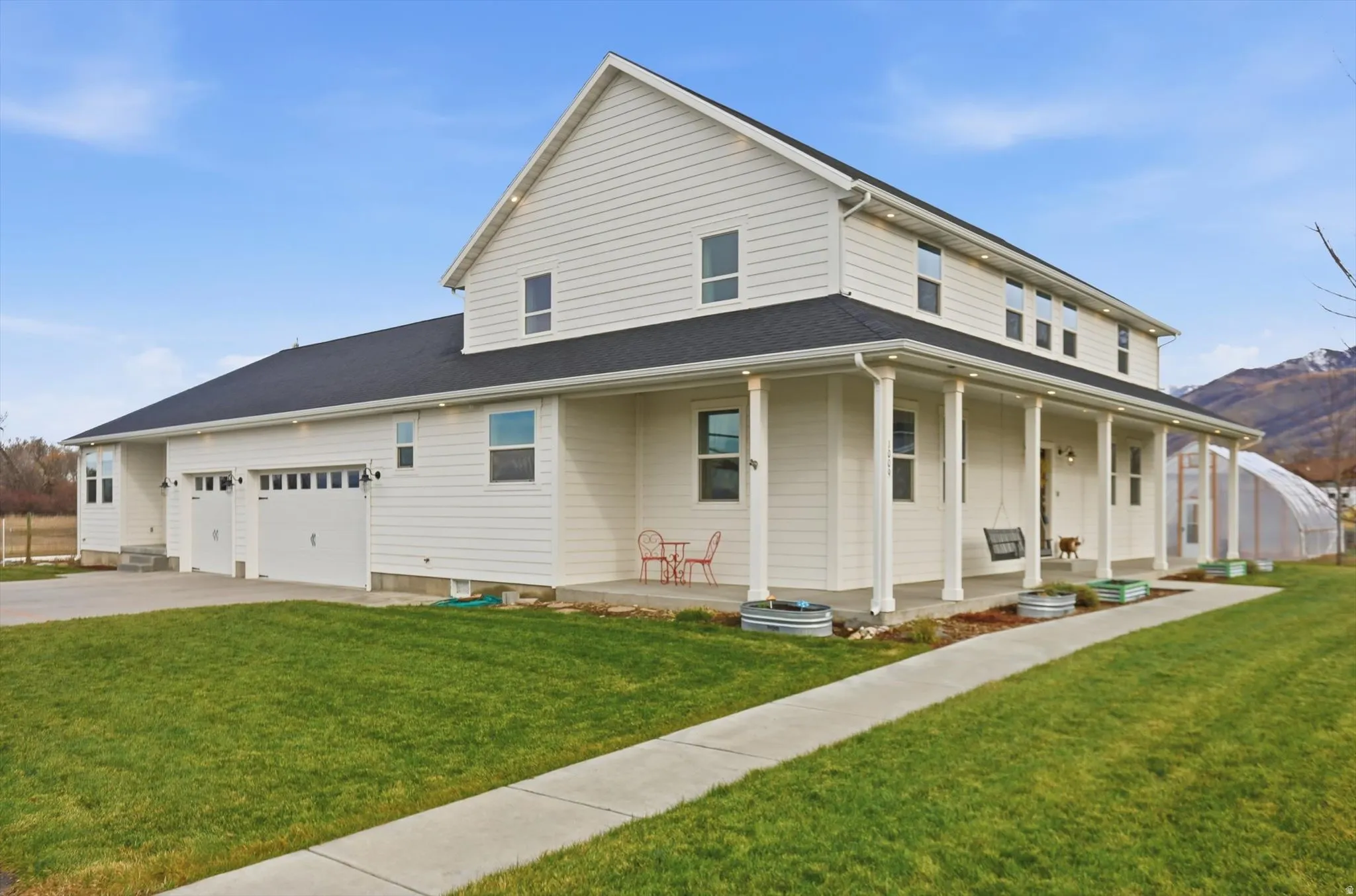 View of front of house with a front lawn, a large porch, concrete driveway, and an attached 3 car garage