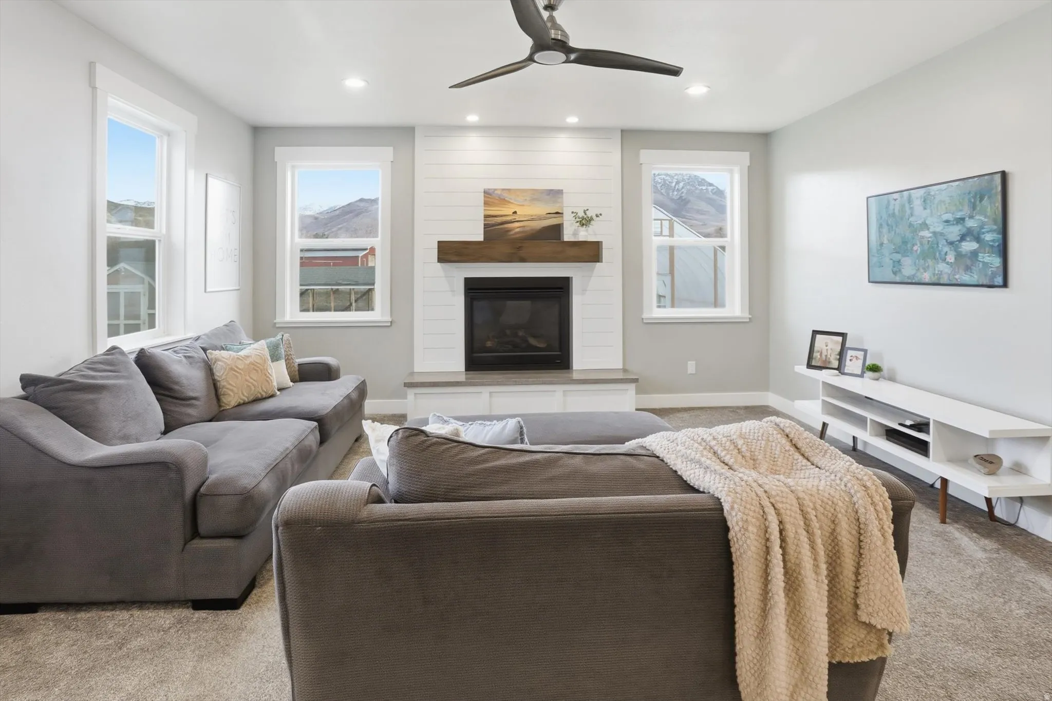 Living area featuring carpet, ceiling fan, recessed lighting, plenty of natural light, and a fireplace