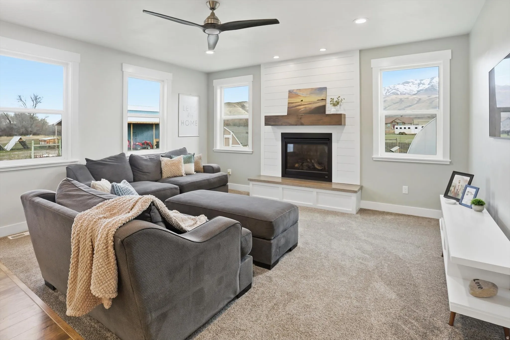 Carpeted living area with a fireplace, recessed lighting, and ceiling fan