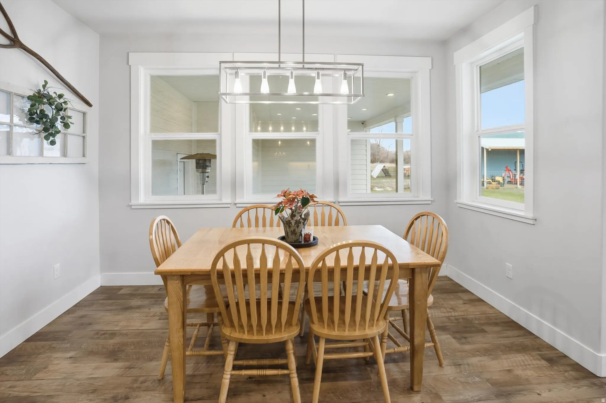 Dining area with dark wood-style floors and baseboards