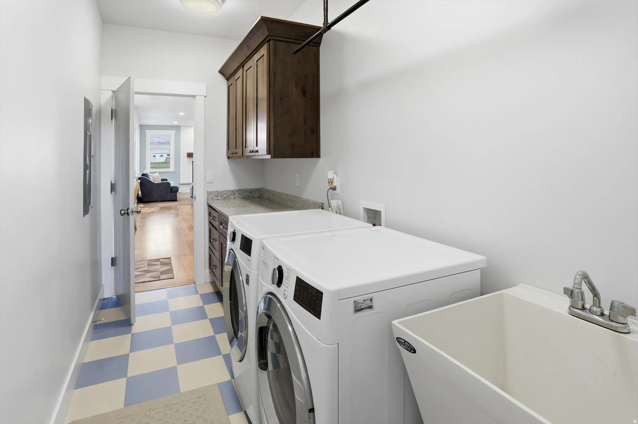 Laundry area featuring light flooring, washing machine and dryer, and cabinet space