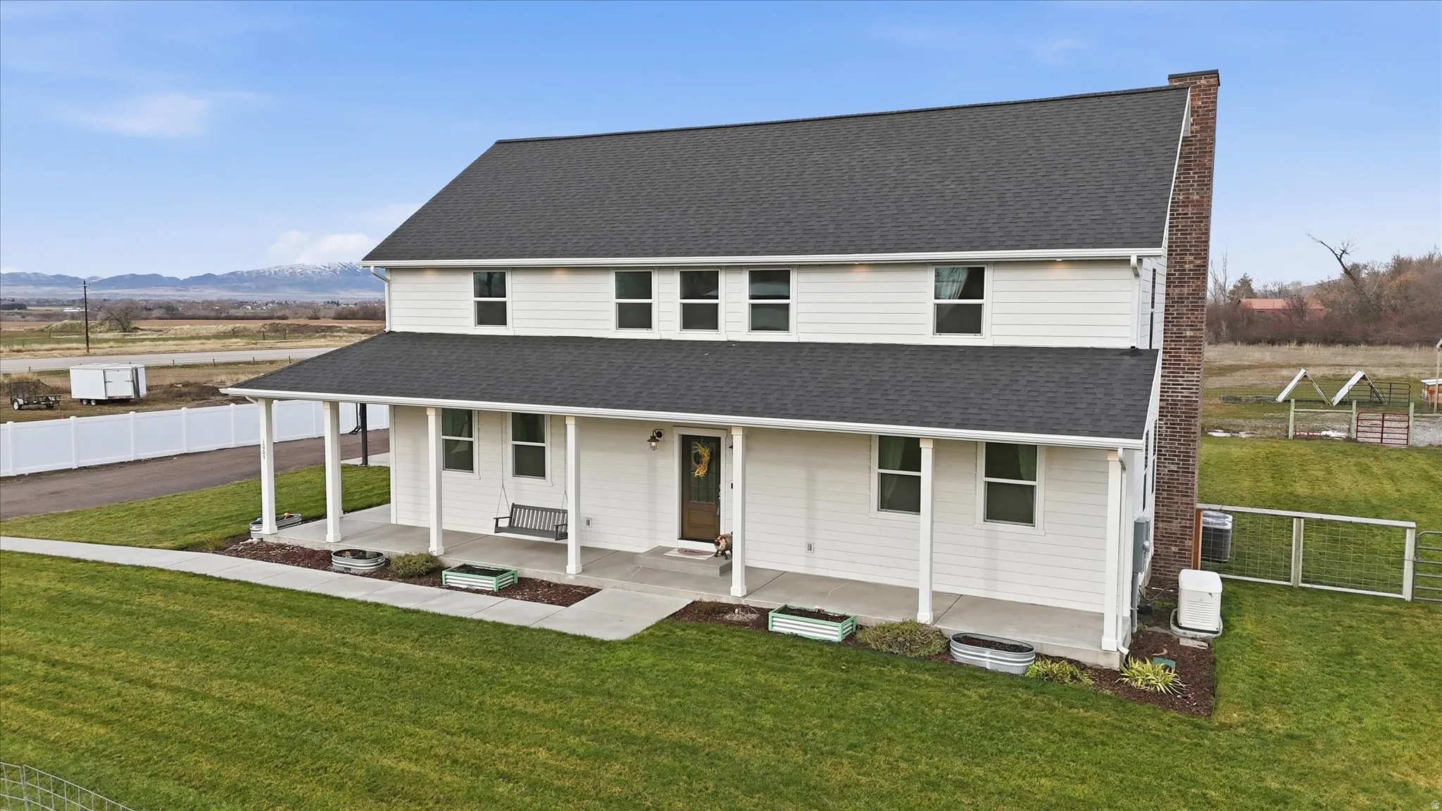 Farmhouse with covered porch, a mountain view, and roof with shingles