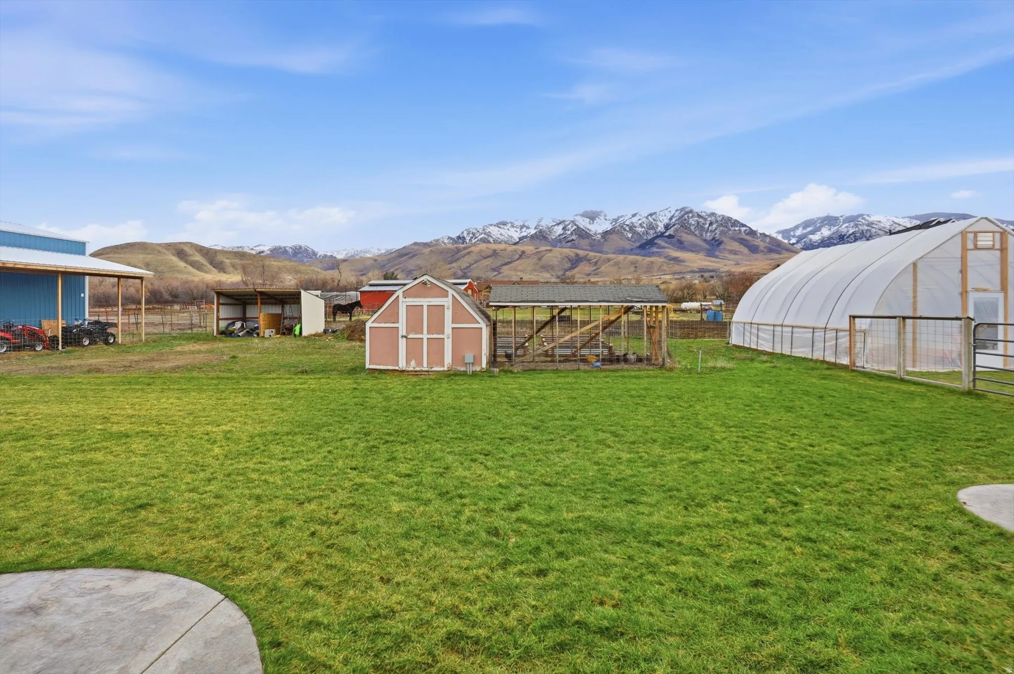 View of yard featuring an outdoor structure, a mountain view, and an exterior structure, shed and greenhouse
