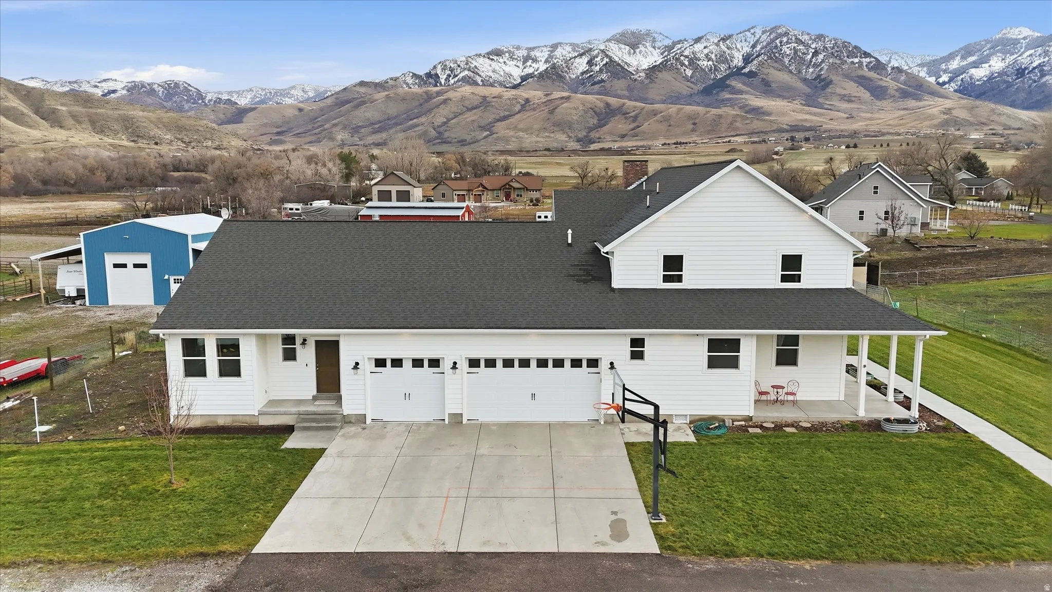 View of front facade with a front lawn, a mountain view, driveway, and covered porch