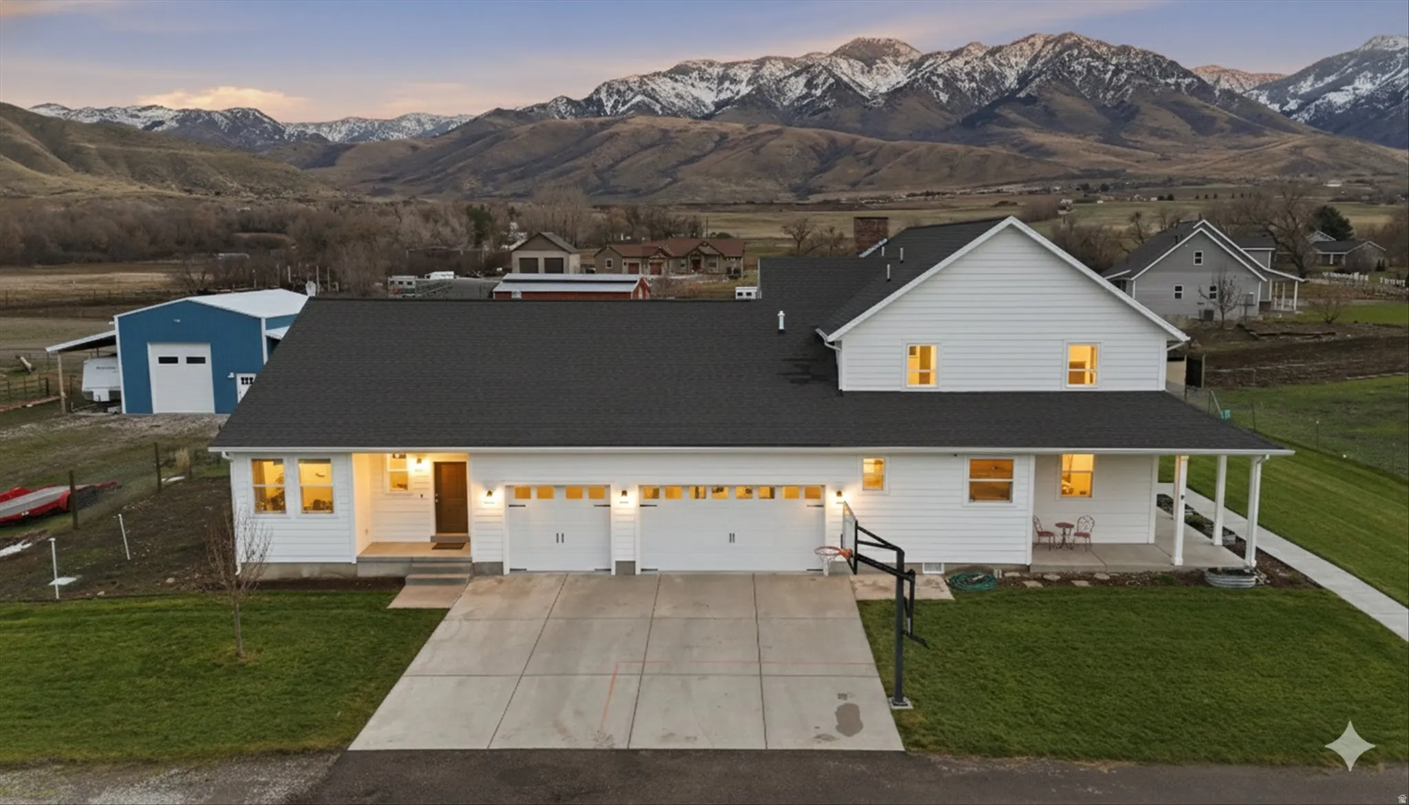 Modern farmhouse with a lawn, concrete driveway, a mountain view, and a porch