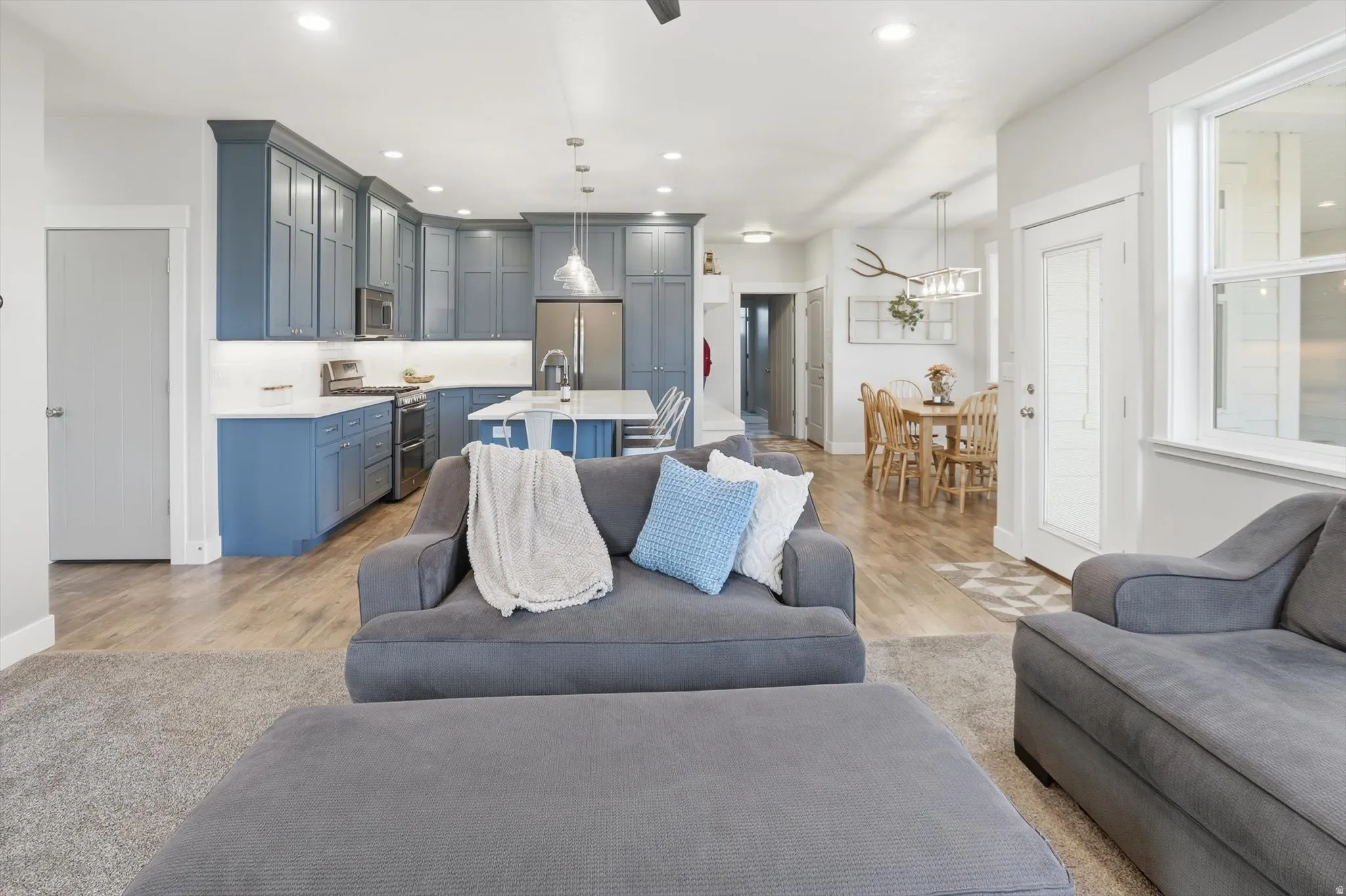 Living room with light wood finished floors and recessed lighting