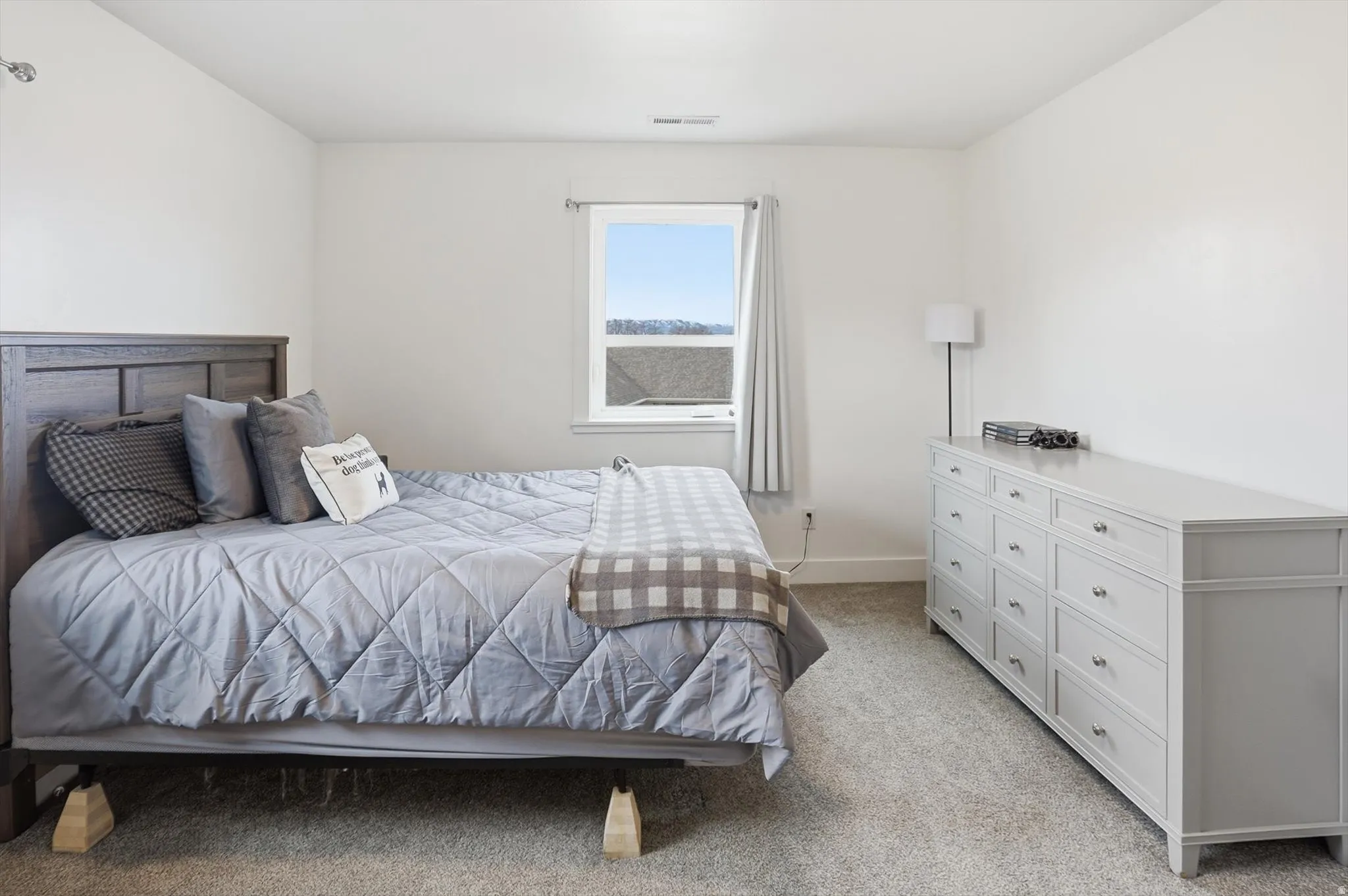Bedroom featuring light colored carpet and baseboards