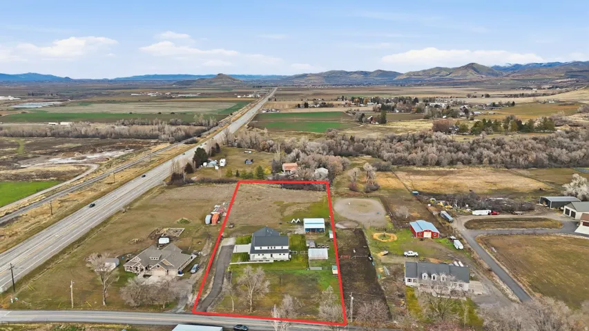 Aerial overview of property's location with a mountainous background and property parcel outlined