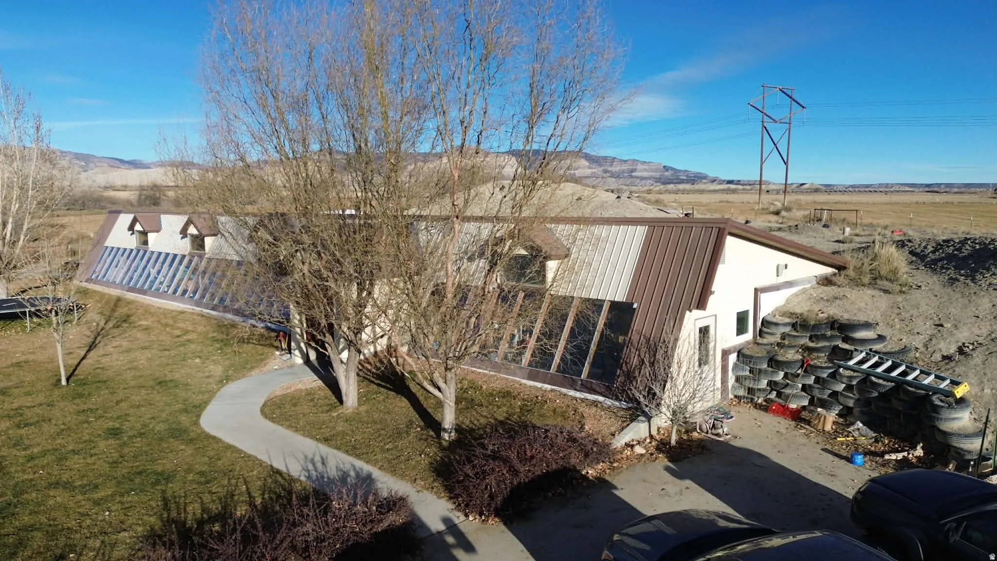 View of side of home featuring a lawn and a mountain view