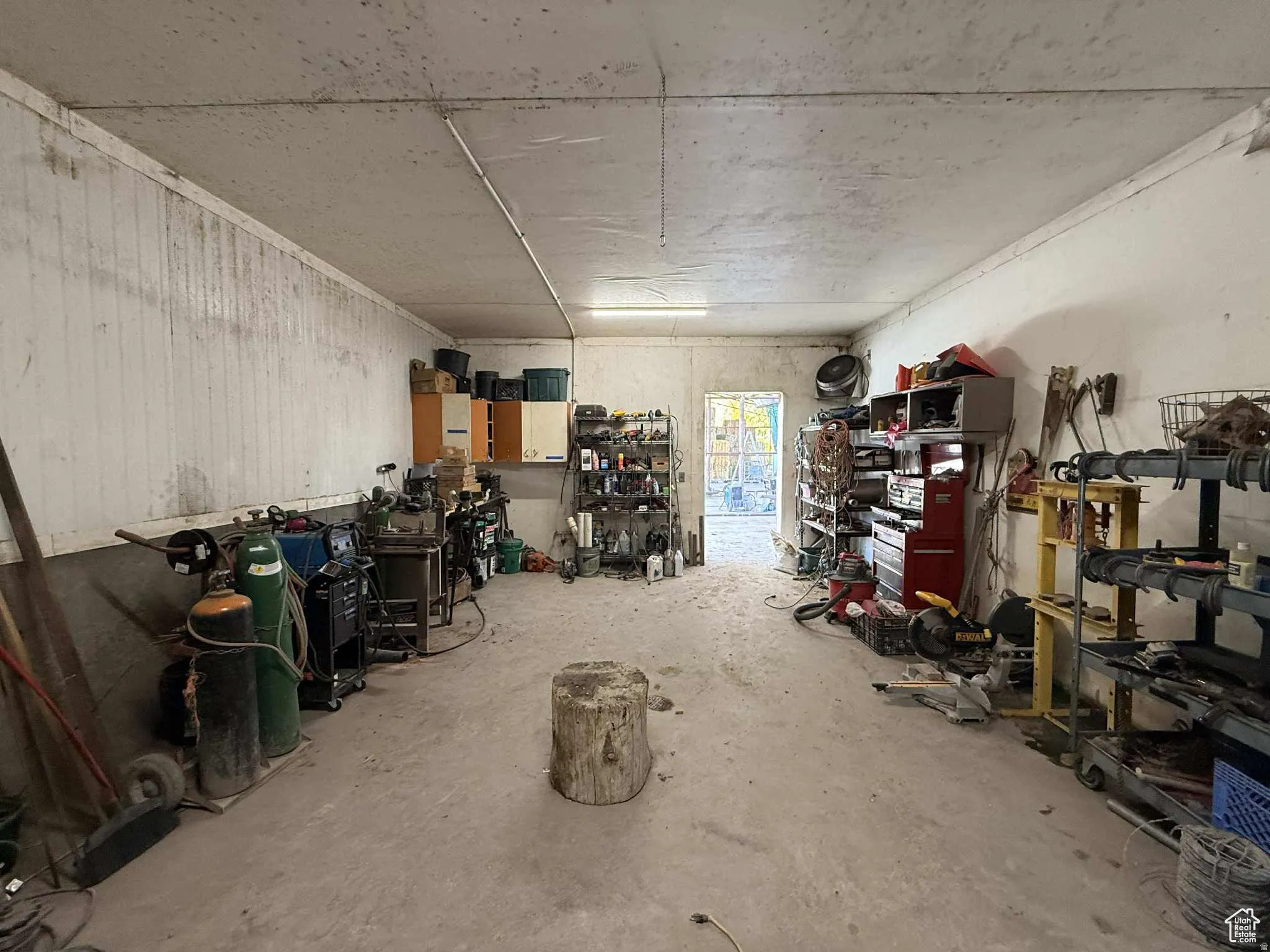 Miscellaneous room featuring unfinished concrete flooring and a garage