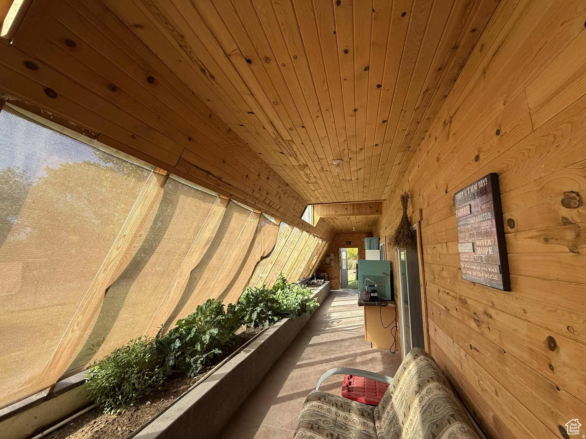 Hall featuring wood walls, wooden ceiling, and vaulted ceiling