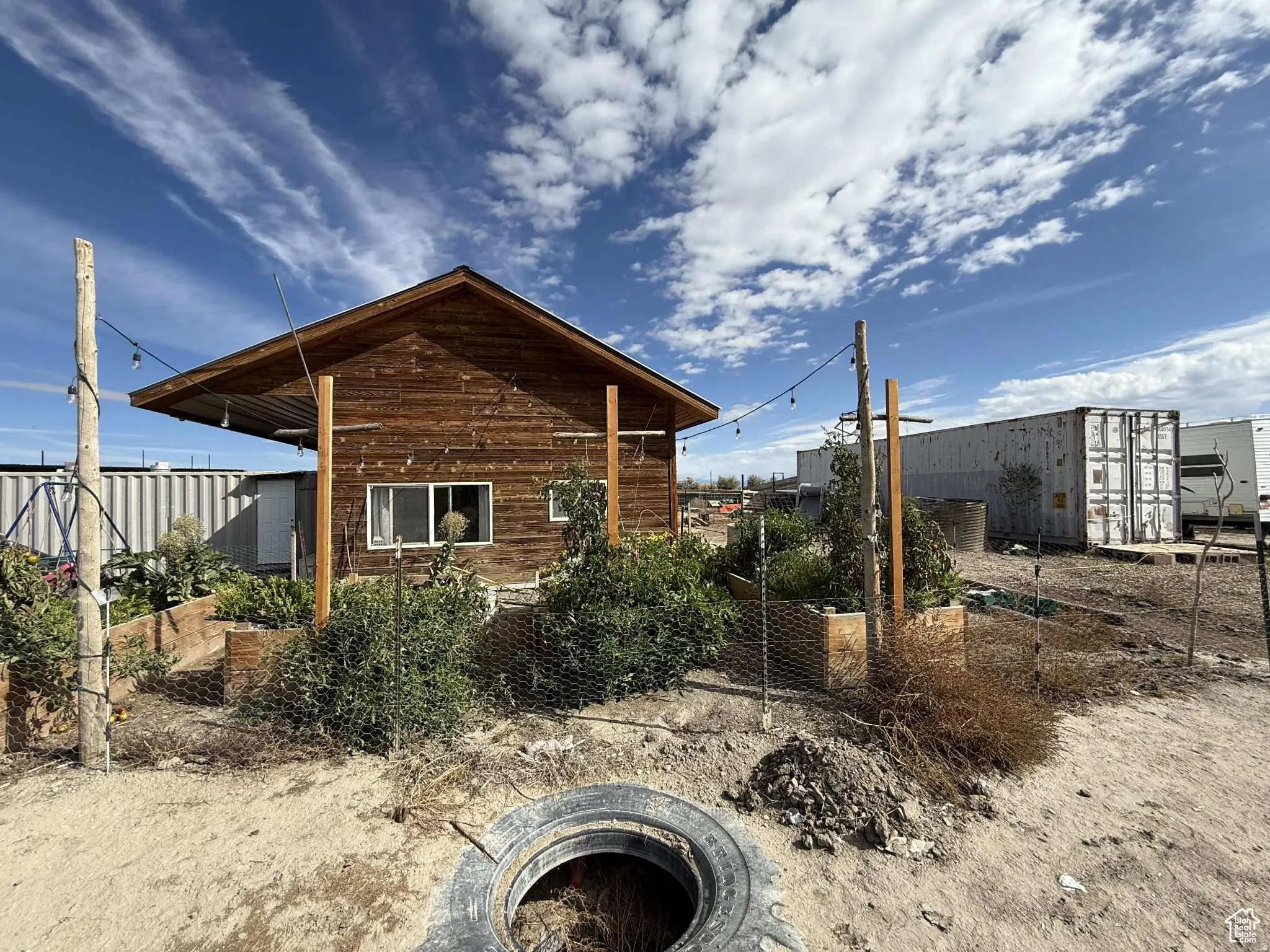 View of side of property featuring a garden and an outdoor fire pit