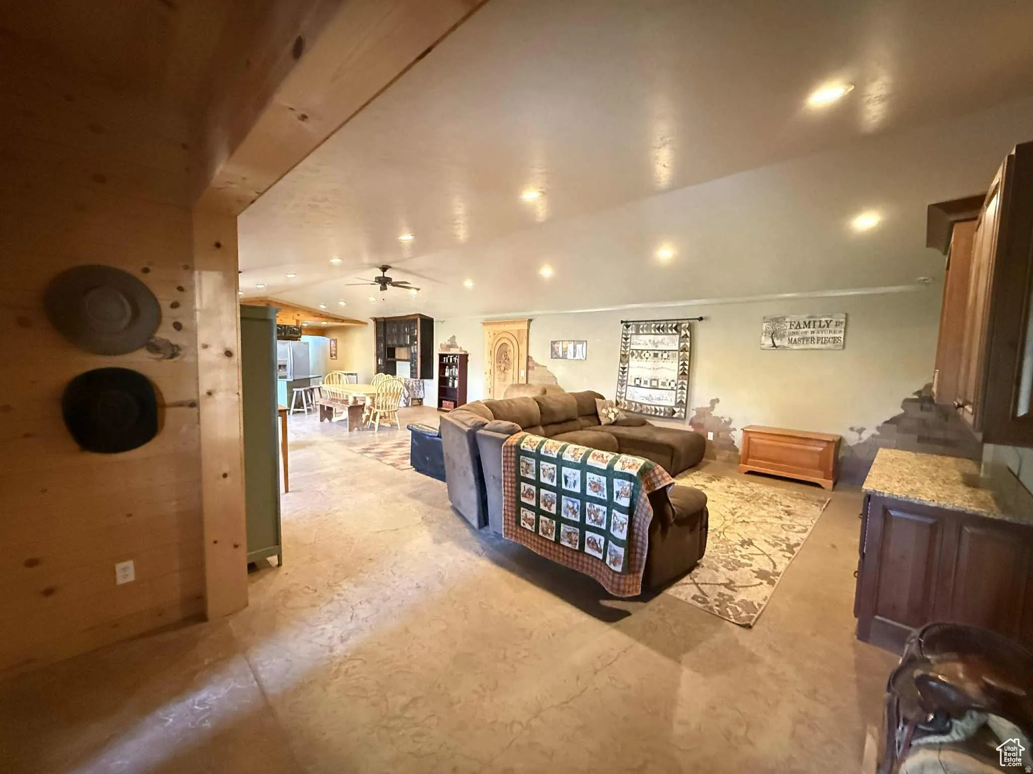 Living area with ceiling fan, concrete floors, and lofted ceiling