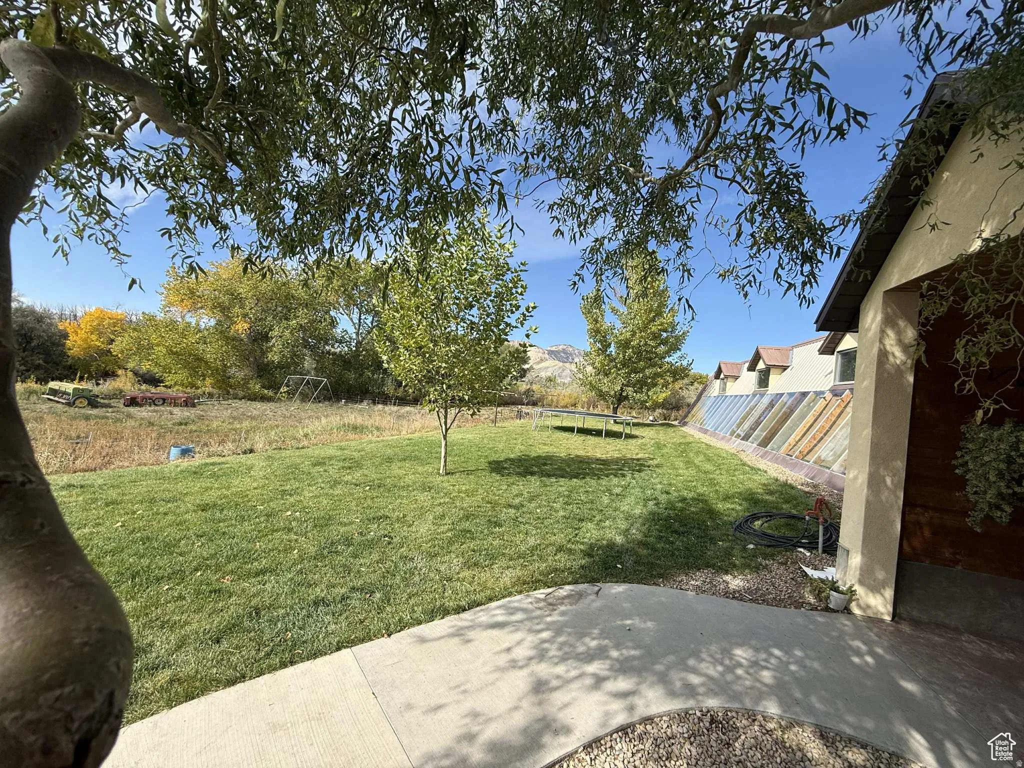 Fenced backyard featuring a trampoline