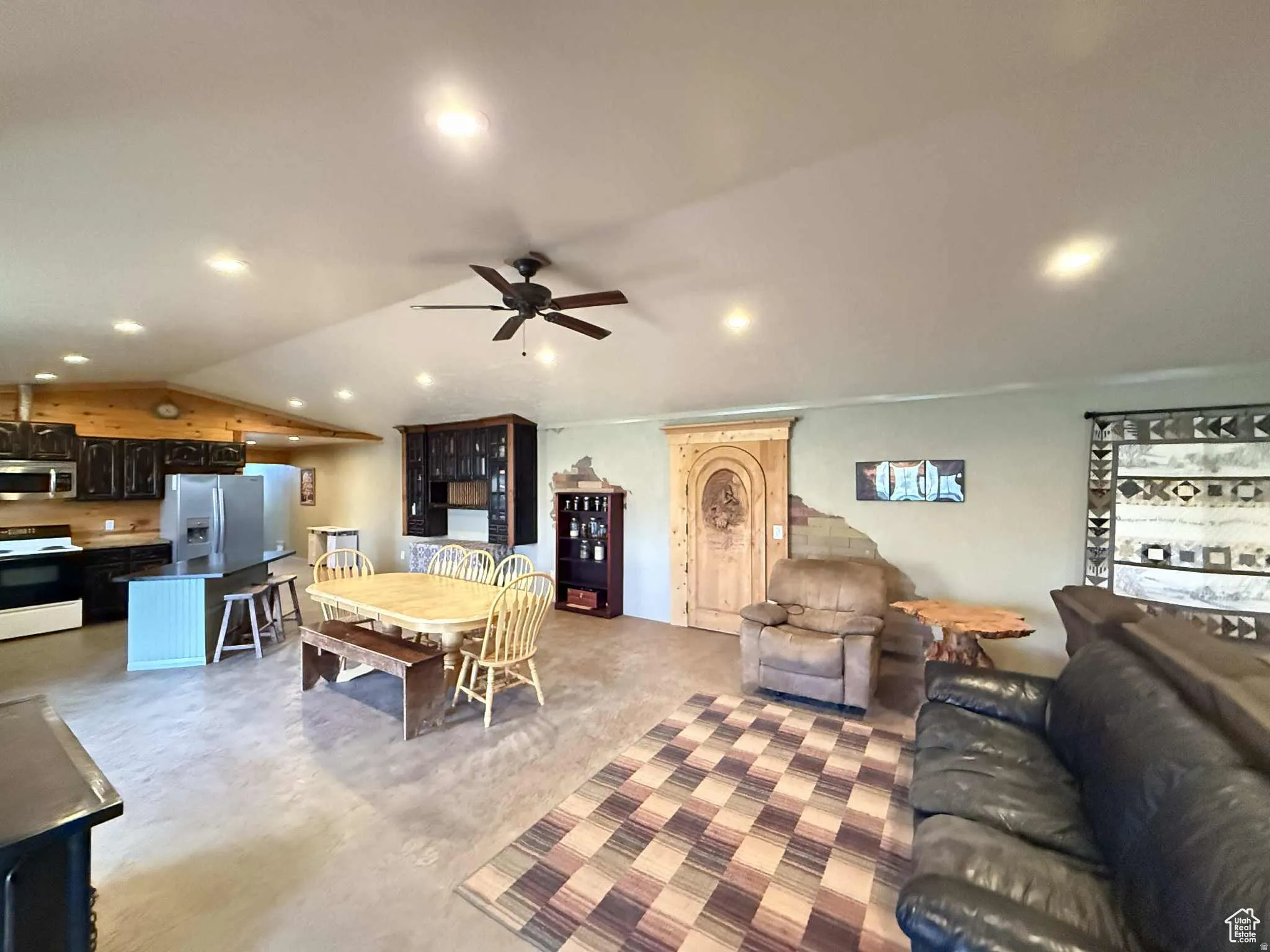 Dining space featuring finished concrete floors, a ceiling fan, recessed lighting, and vaulted ceiling