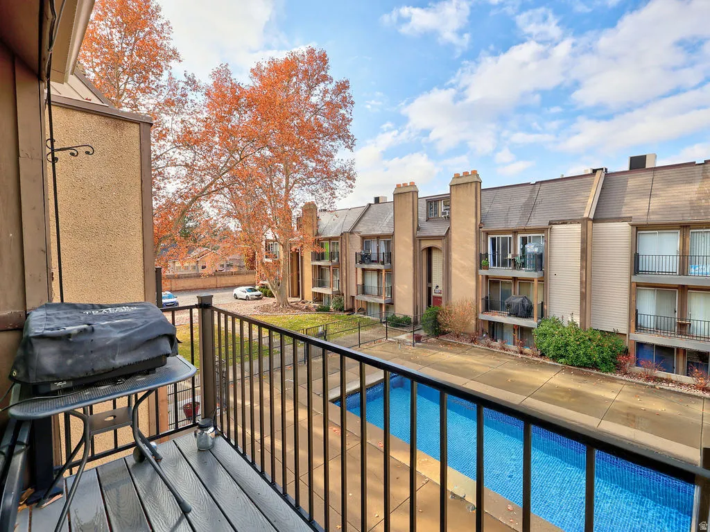 Balcony featuring grilling area and view of pool. Pool cover photoshopped.