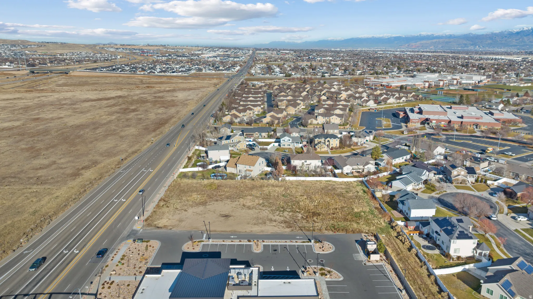Aerial overview of property's location with nearby suburban area and a mountainous background