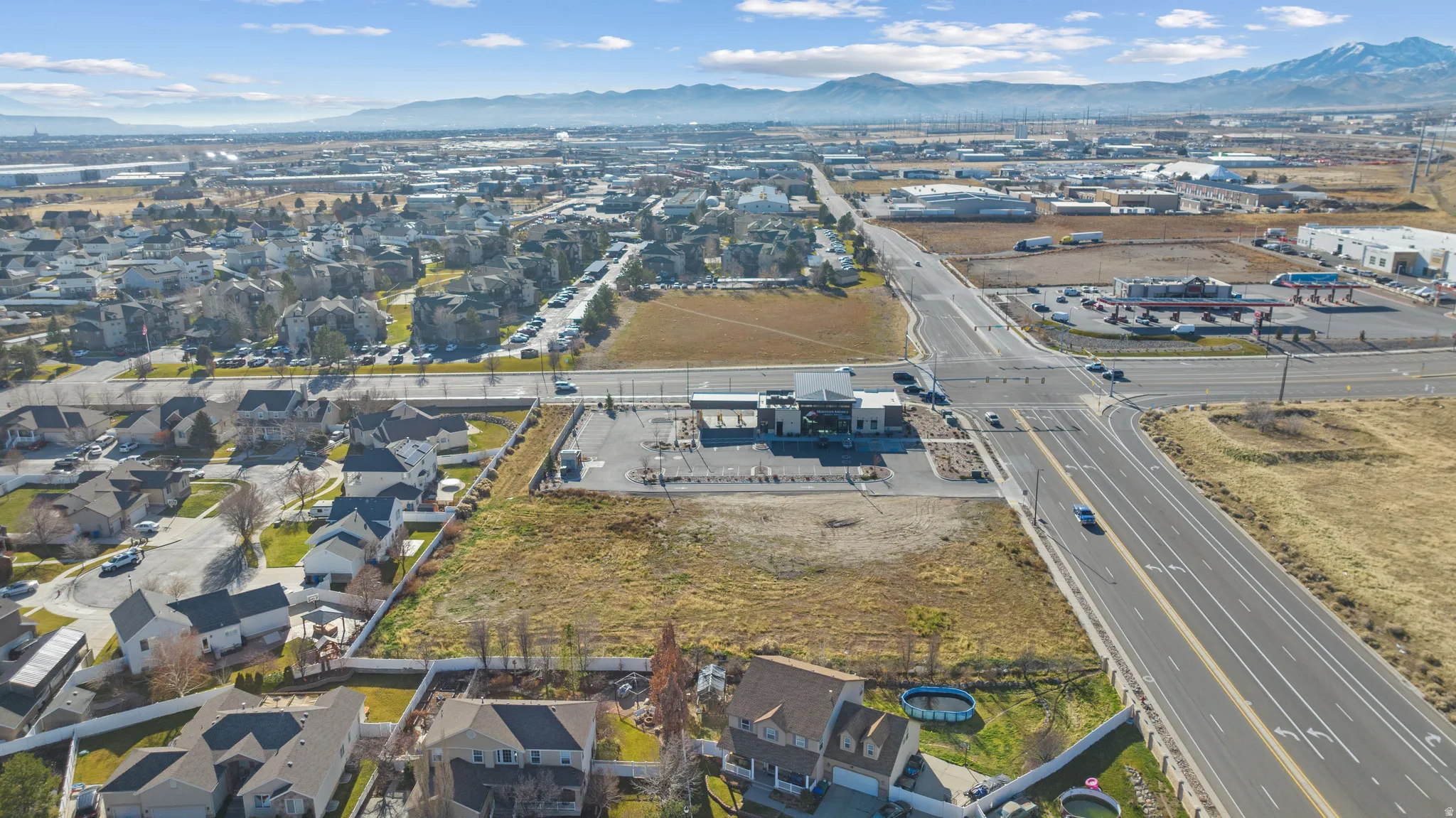 Aerial view of property's location featuring a mountainous background and nearby suburban area