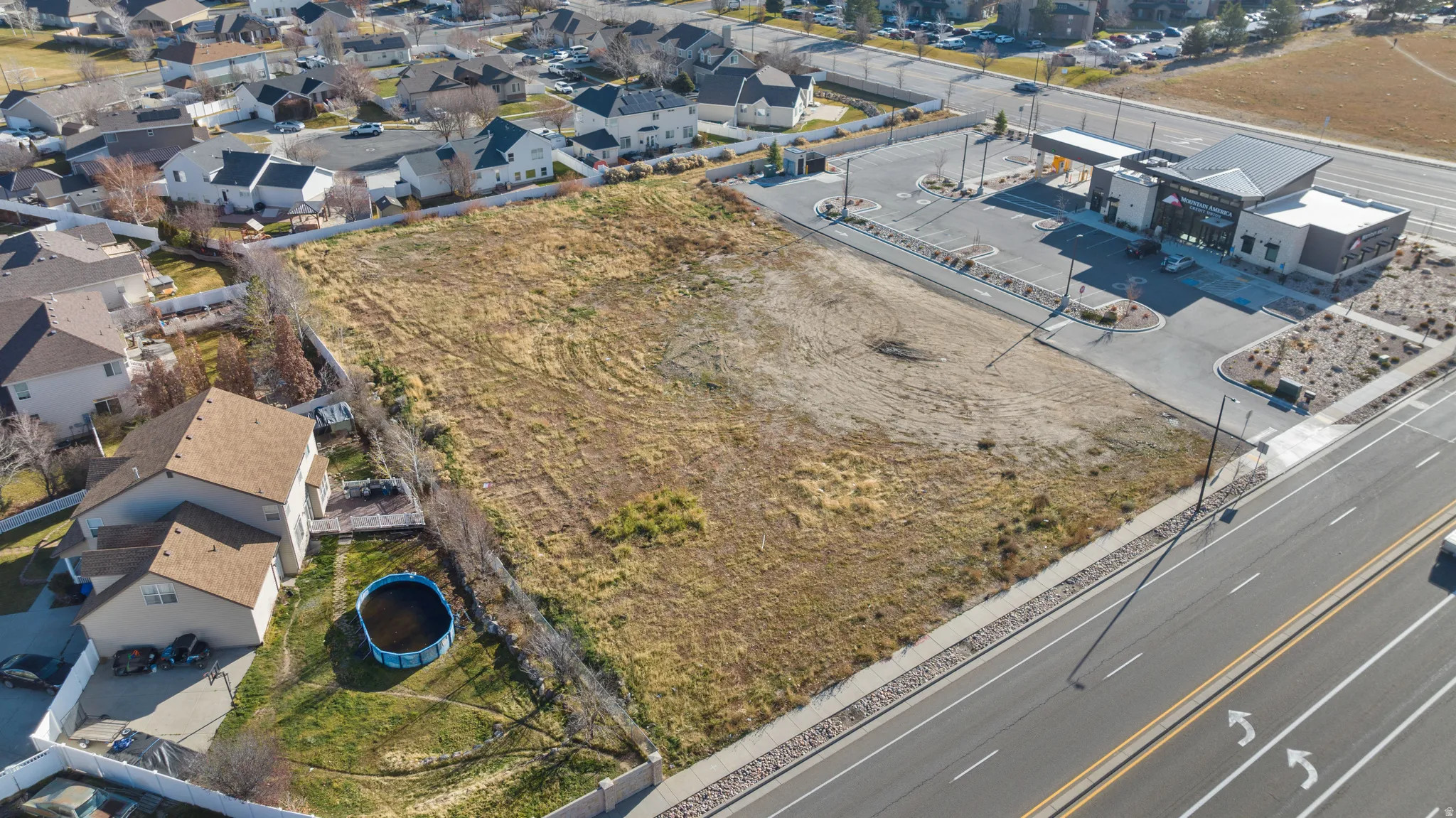 Aerial view of property and surrounding area featuring nearby suburban area